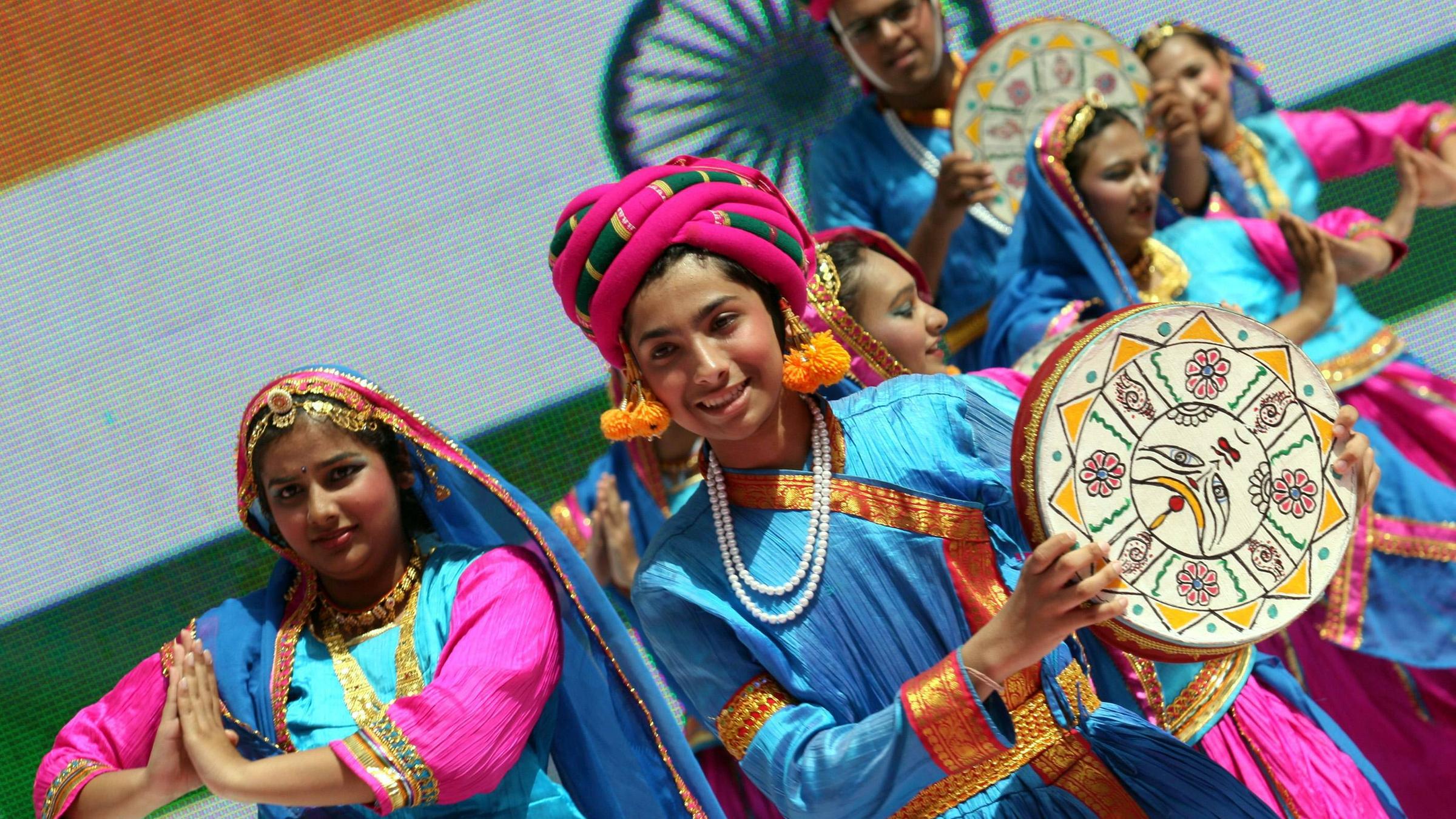 Kinder in traditionellen Gewändern tanzen zusammen