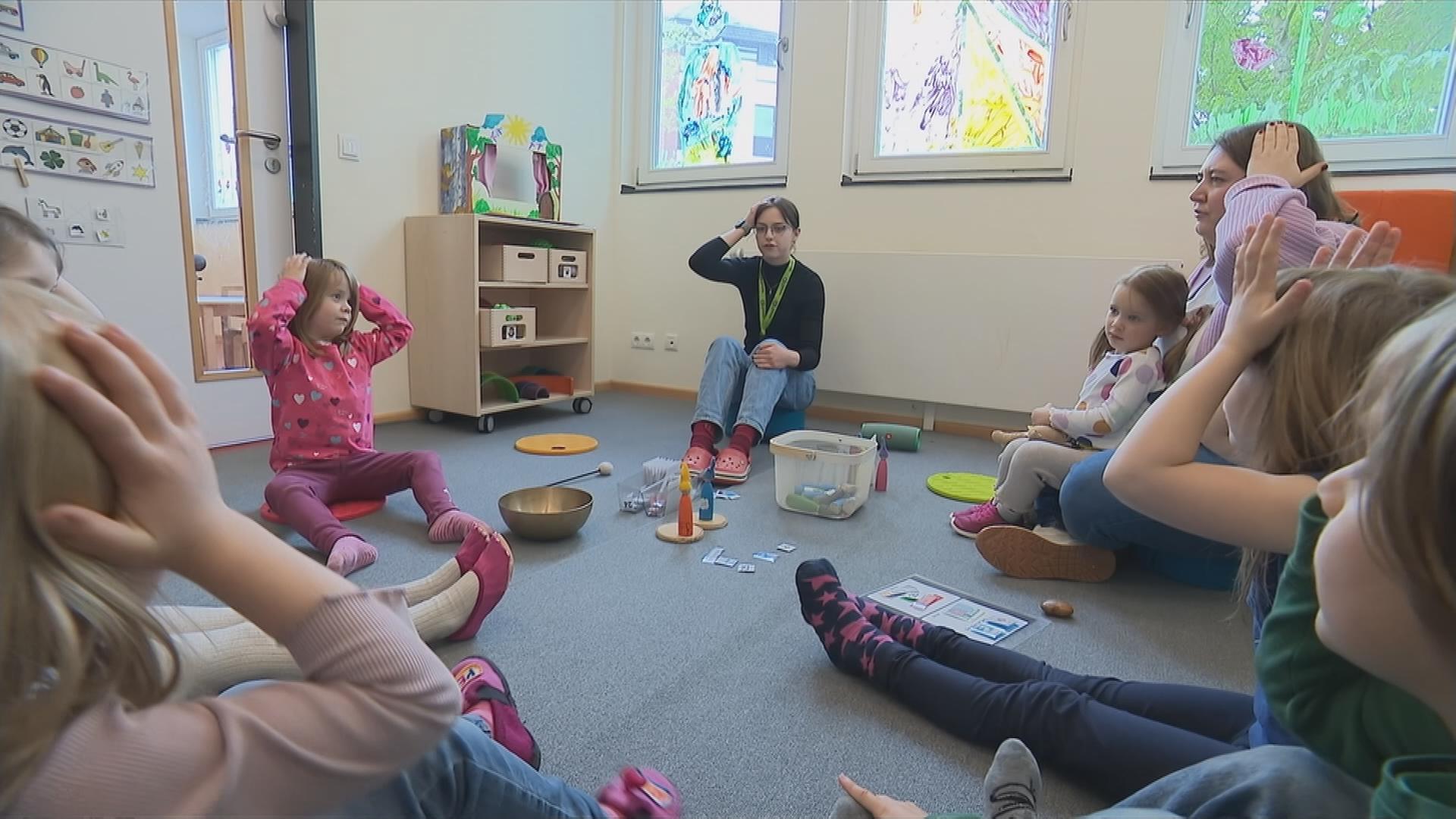 Freiwillige macht Sitzkreis mit den Kindergartenkindern.