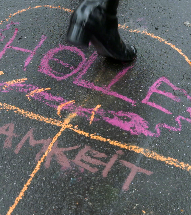 Das Kinderspiel "Himmel und Hölle" mit Kreideschriftzug "Einsamkeit" auf dem Boden