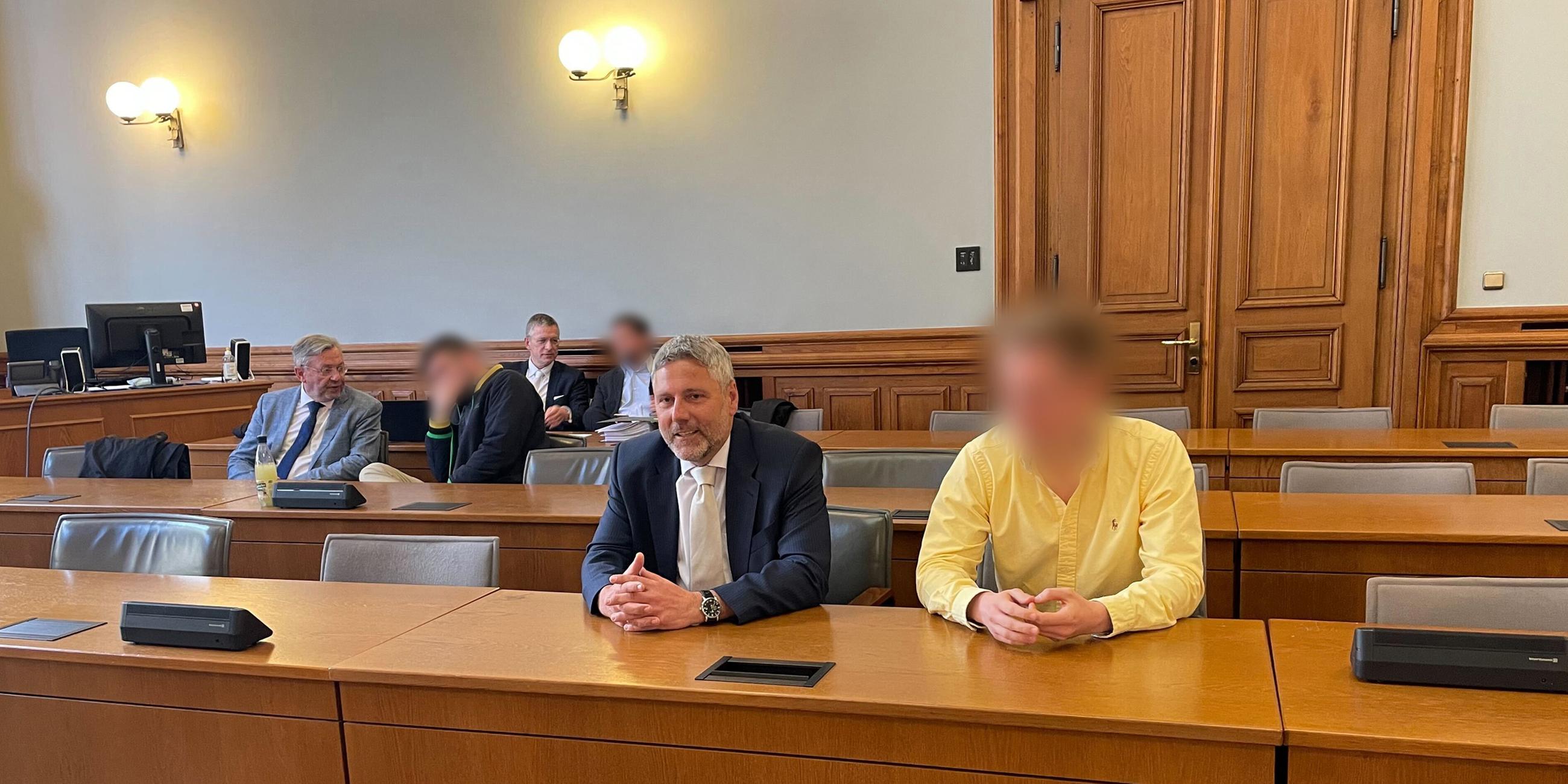  Drei der vier Angeklagten im "Kinderzimmer-Dealer"-Prozess sitzen neben ihren Anwälten in einem Saal vom Landgericht Leipzig. 