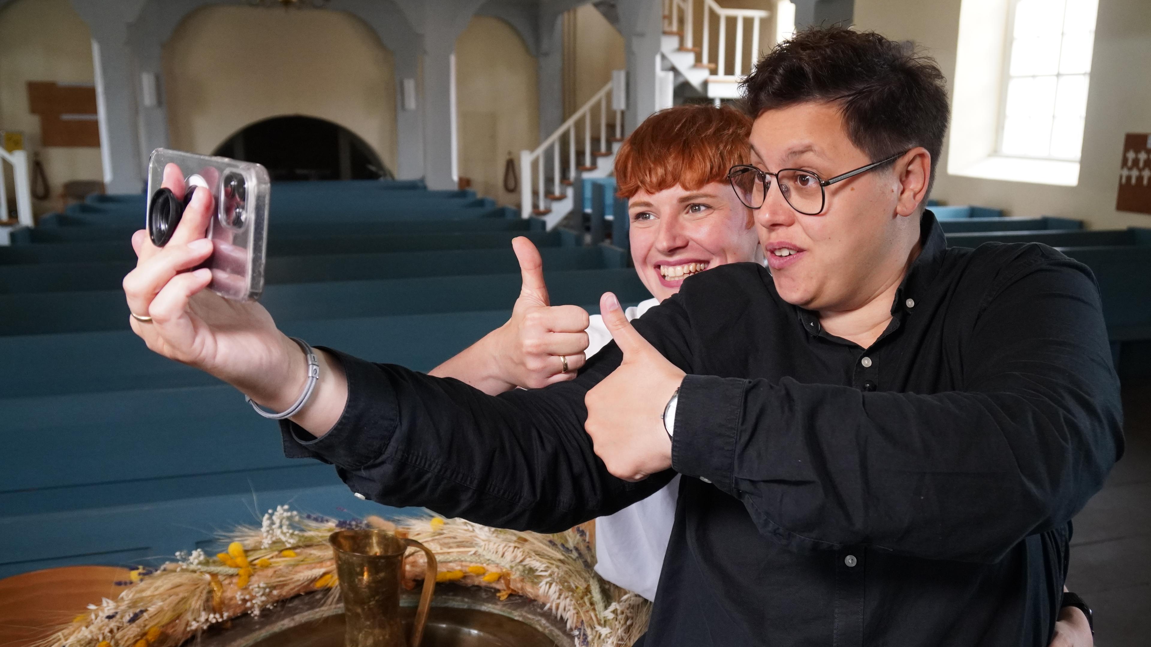 Ellen und Steffi Radtke posieren für ein Handy-Selfie in der Kirche.