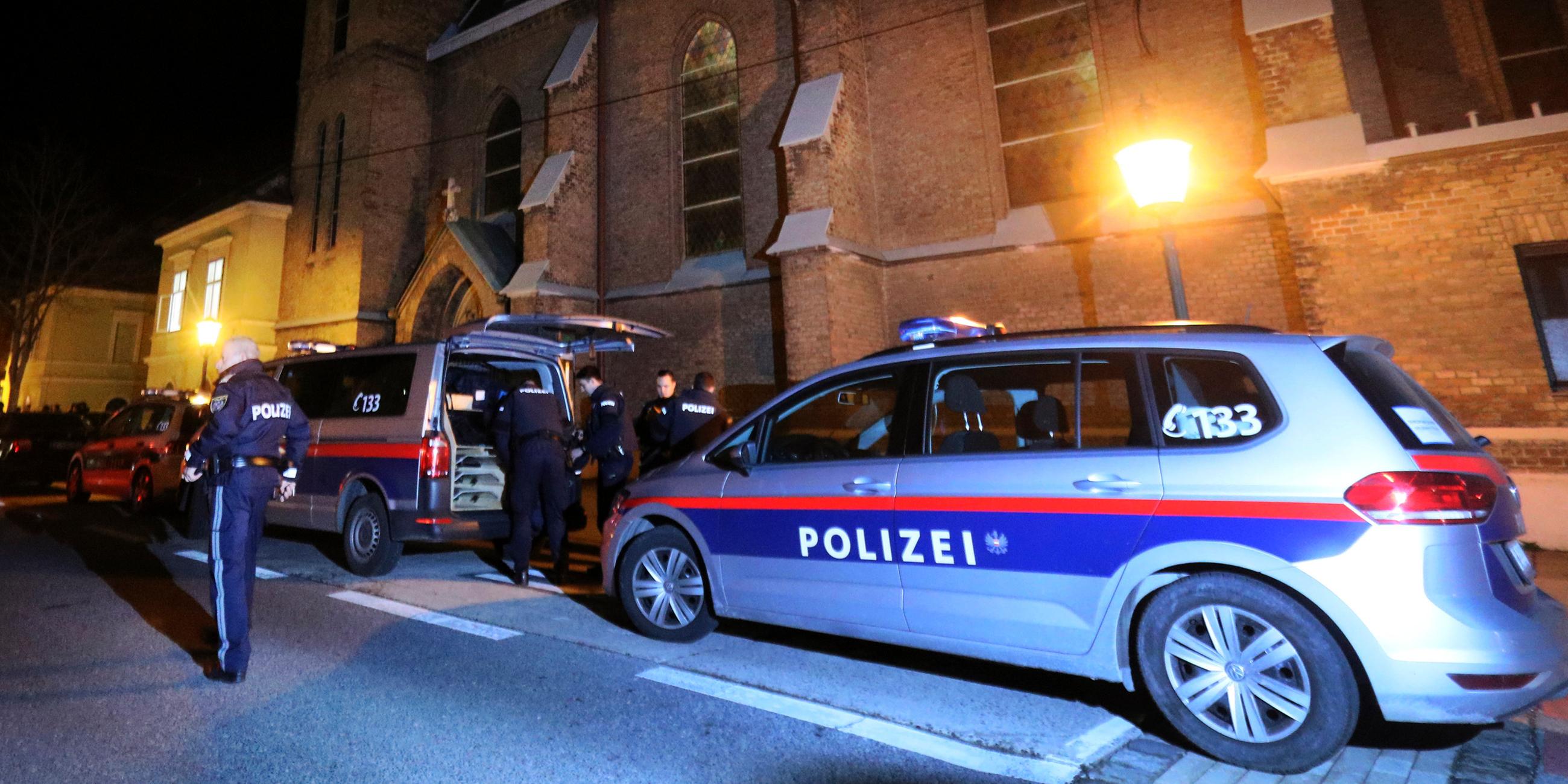 Archiv: Polizisten und zwei Polizeiautos stehen vor einer Kirche in Wien am 27.12.2018