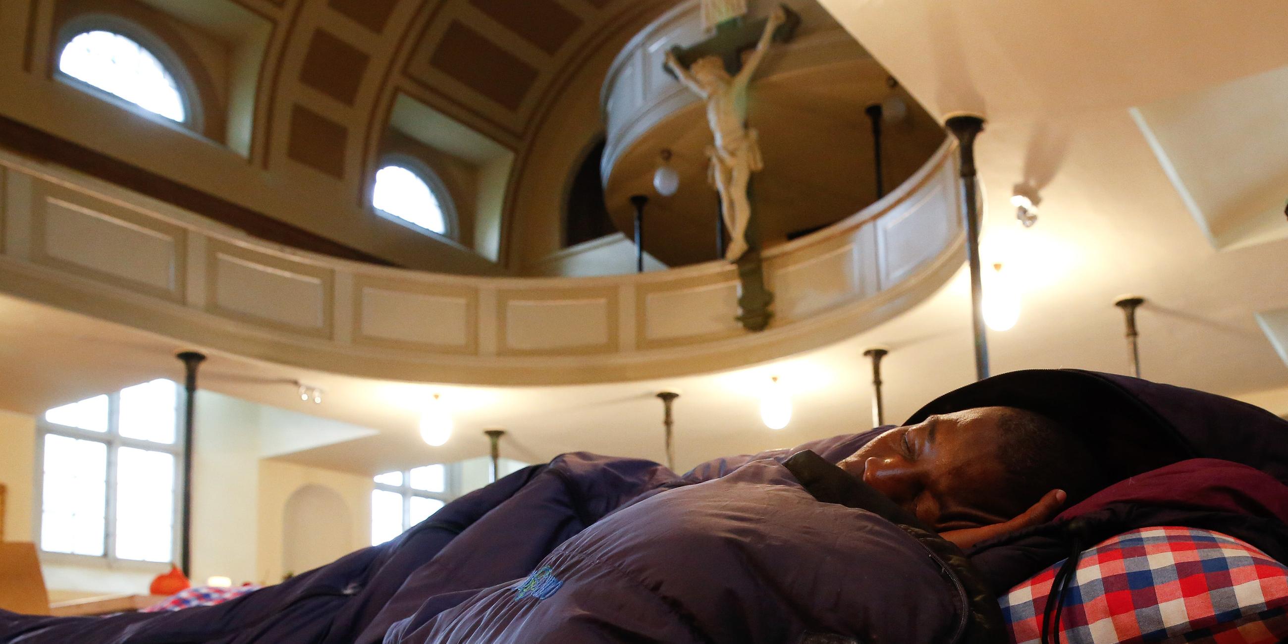 Ein afrikanischer Füchtling schläft am 06.10.2013 in der St. Pauli Kirche in Hamburg. 