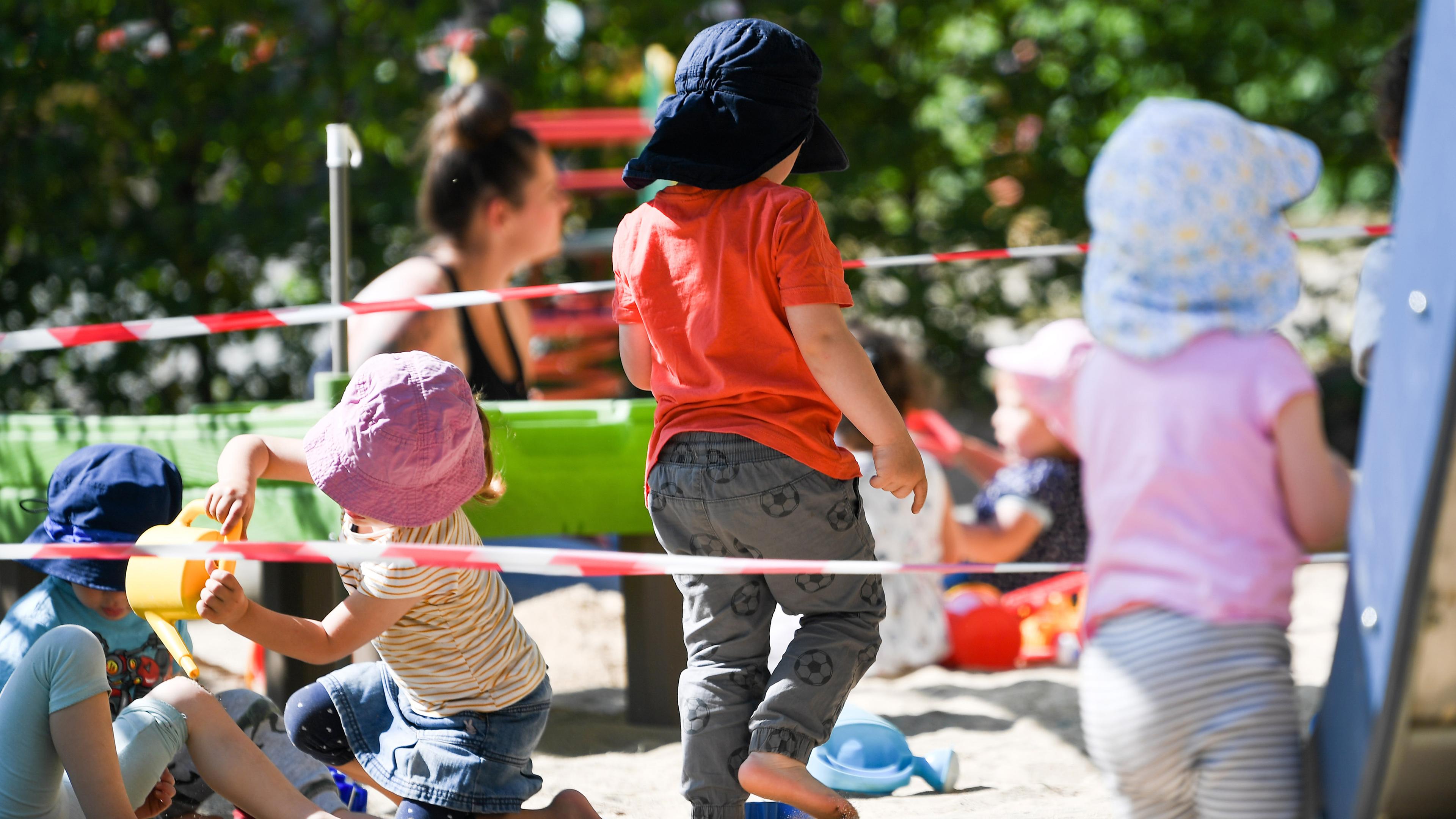 Das Bild zeigt Kinder, die auf einem Spielplatz einer Kita spielen.