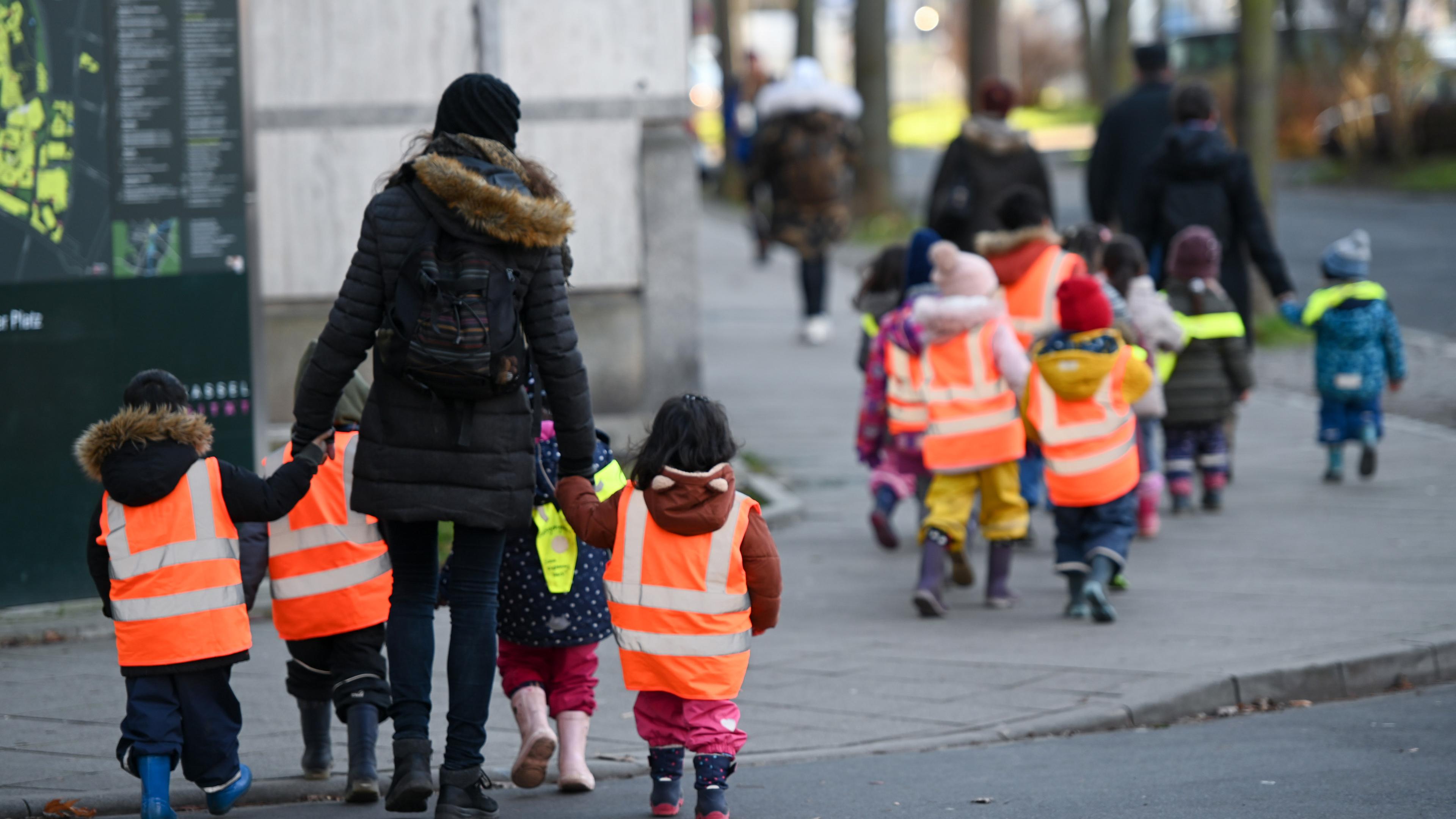 Hessen, Kassel: Kita-Kinder tragen Warnwesten bei einem Ausflug mit ihren Betreuerinnen. Archivbild