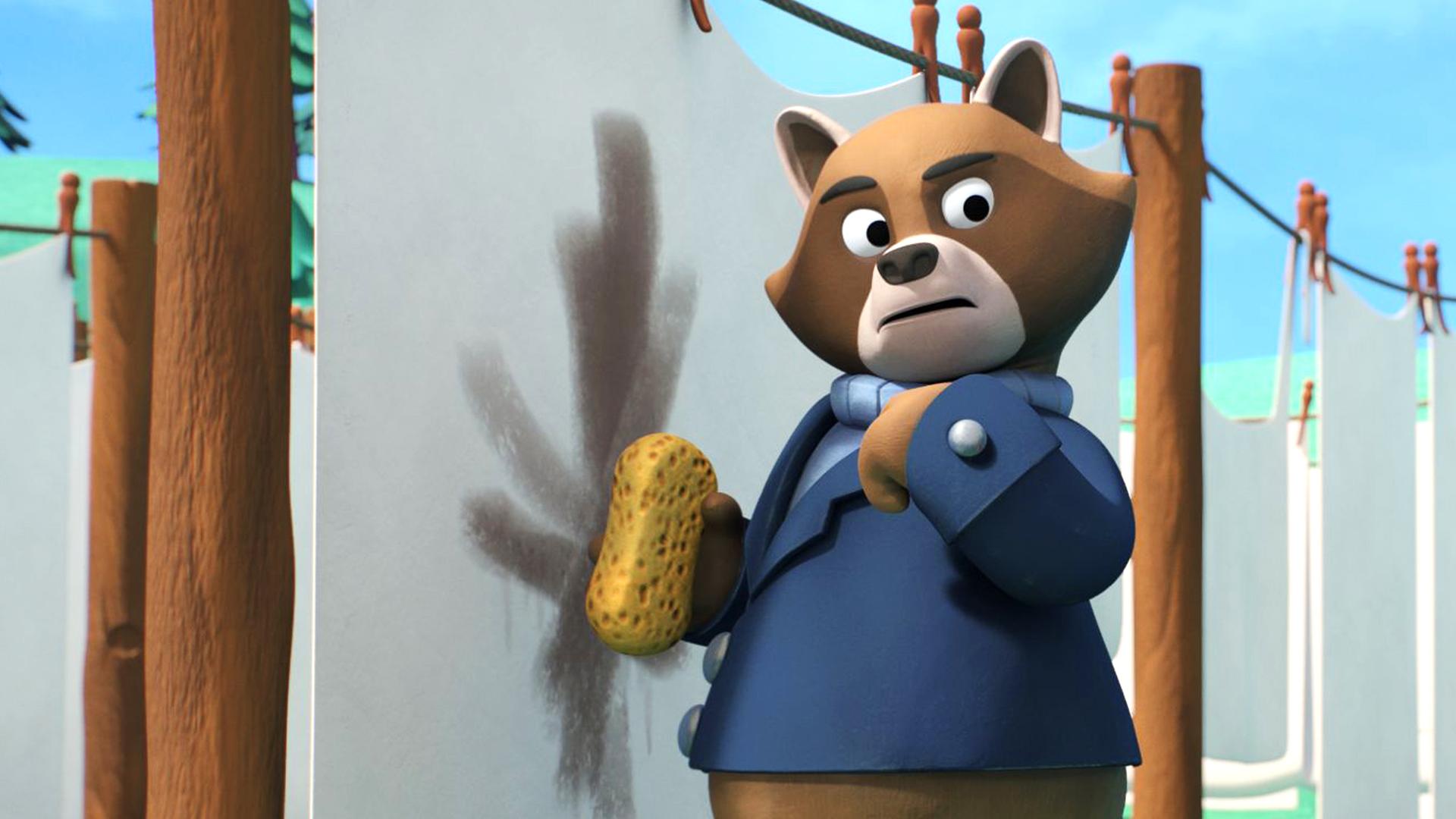 Der Waschbär Addi (links) steht vor einer Wäscheleine, an der ein dreckiges Laken hängt. Er hält einen Schwamm in der Hand und sieht Petzi an, der rechts von ihm steht.