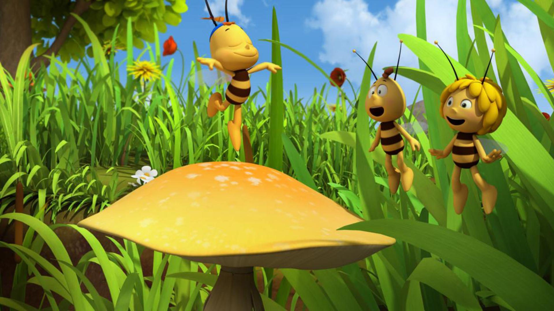 Siggi tanzt auf einer Blume. Er bringt Willi und Maja zum lachen.