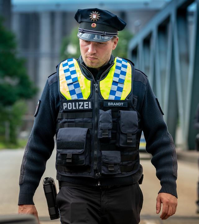 Nick (Raúl Richter) schaut sich einen Pkw am Straßenrand näher an.