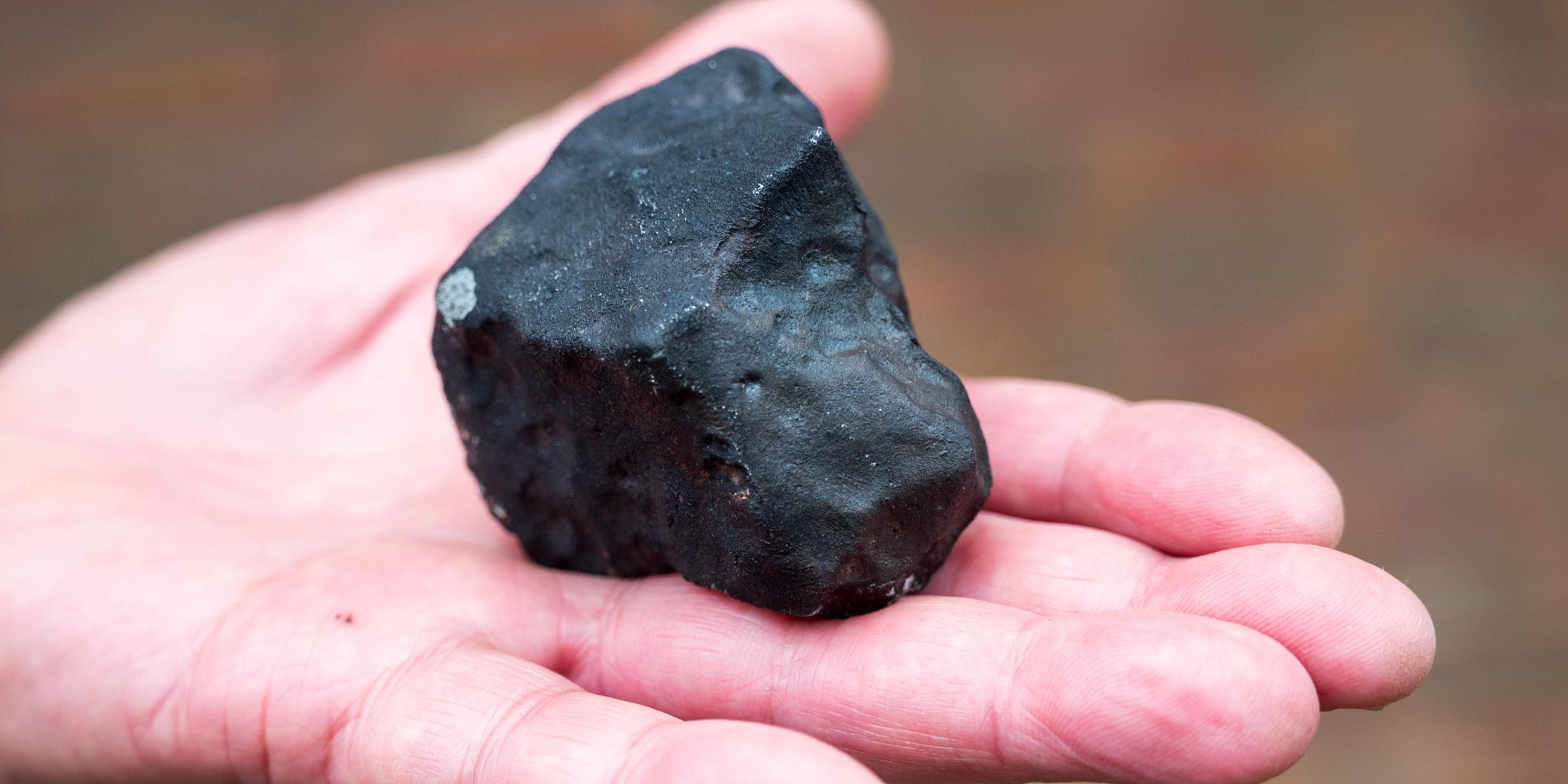 Schleswig-Holstein, Elmshorn: Ein Hausbesitzer hält vor seinem Haus einen kleinen Meteoriten, der niedergegangen ist. 