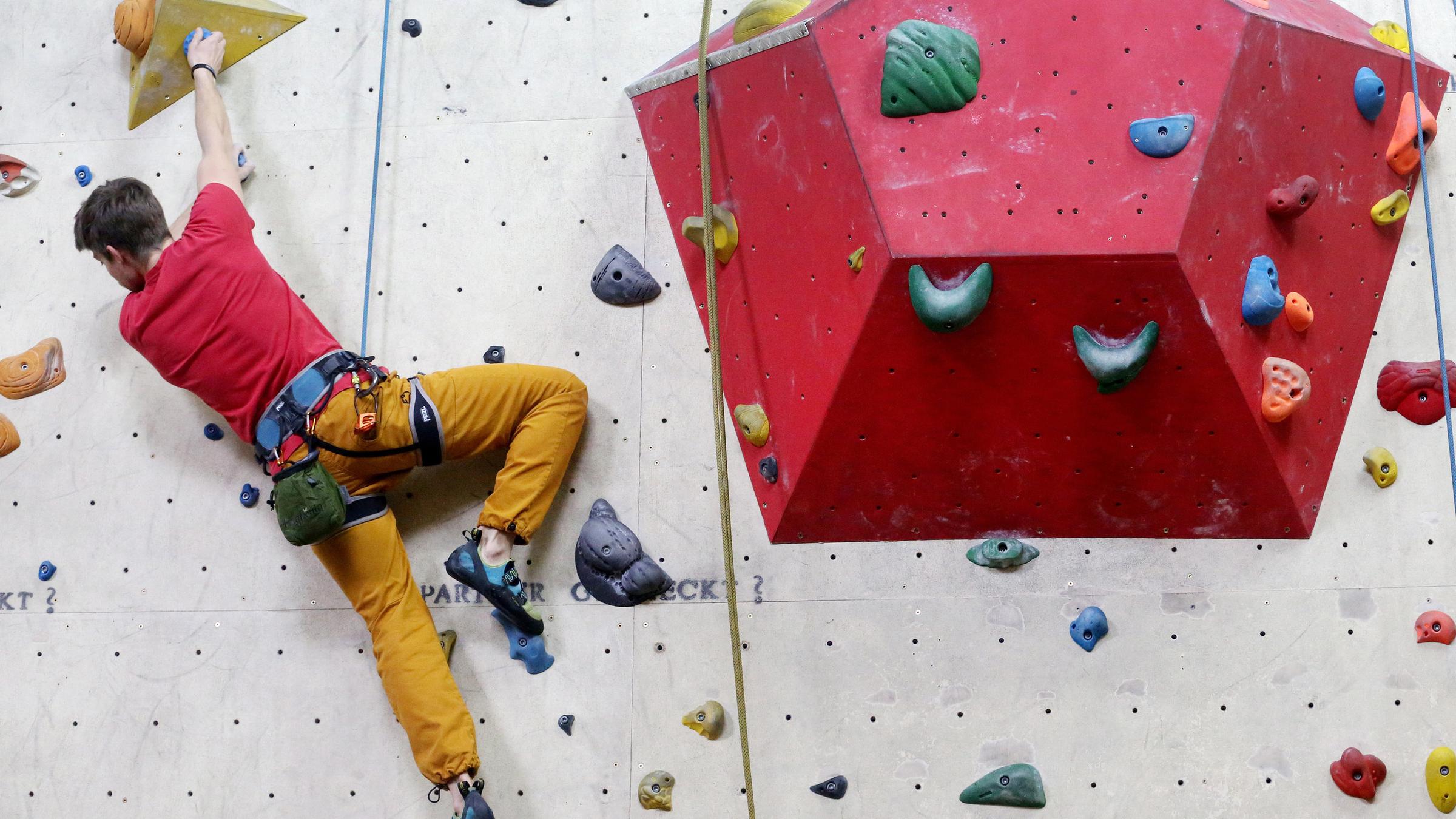 Bolderer an einer Kletterwand