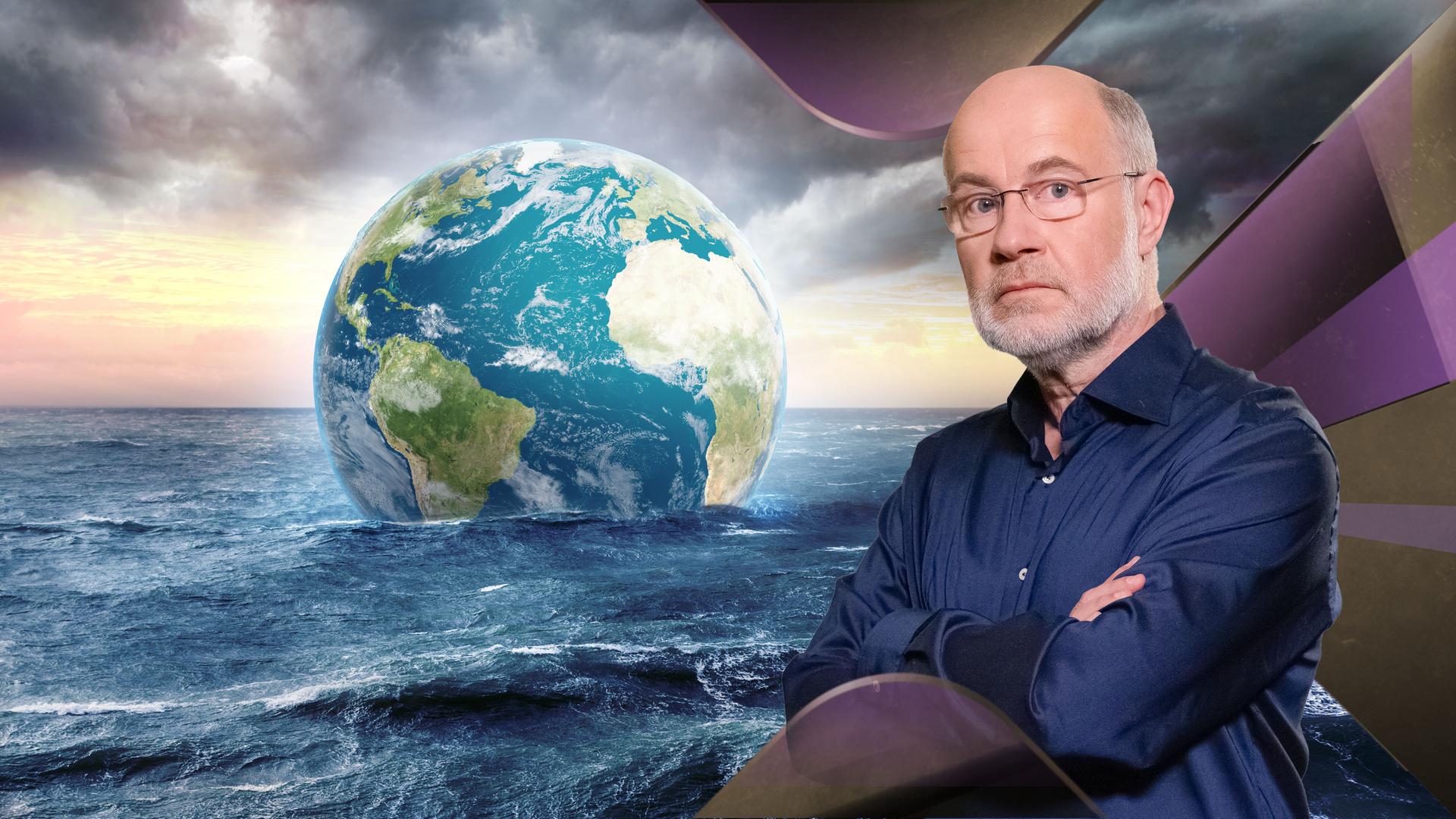 Professor Harald Lesch steht vor Meer mit schwimmender Erdkugel