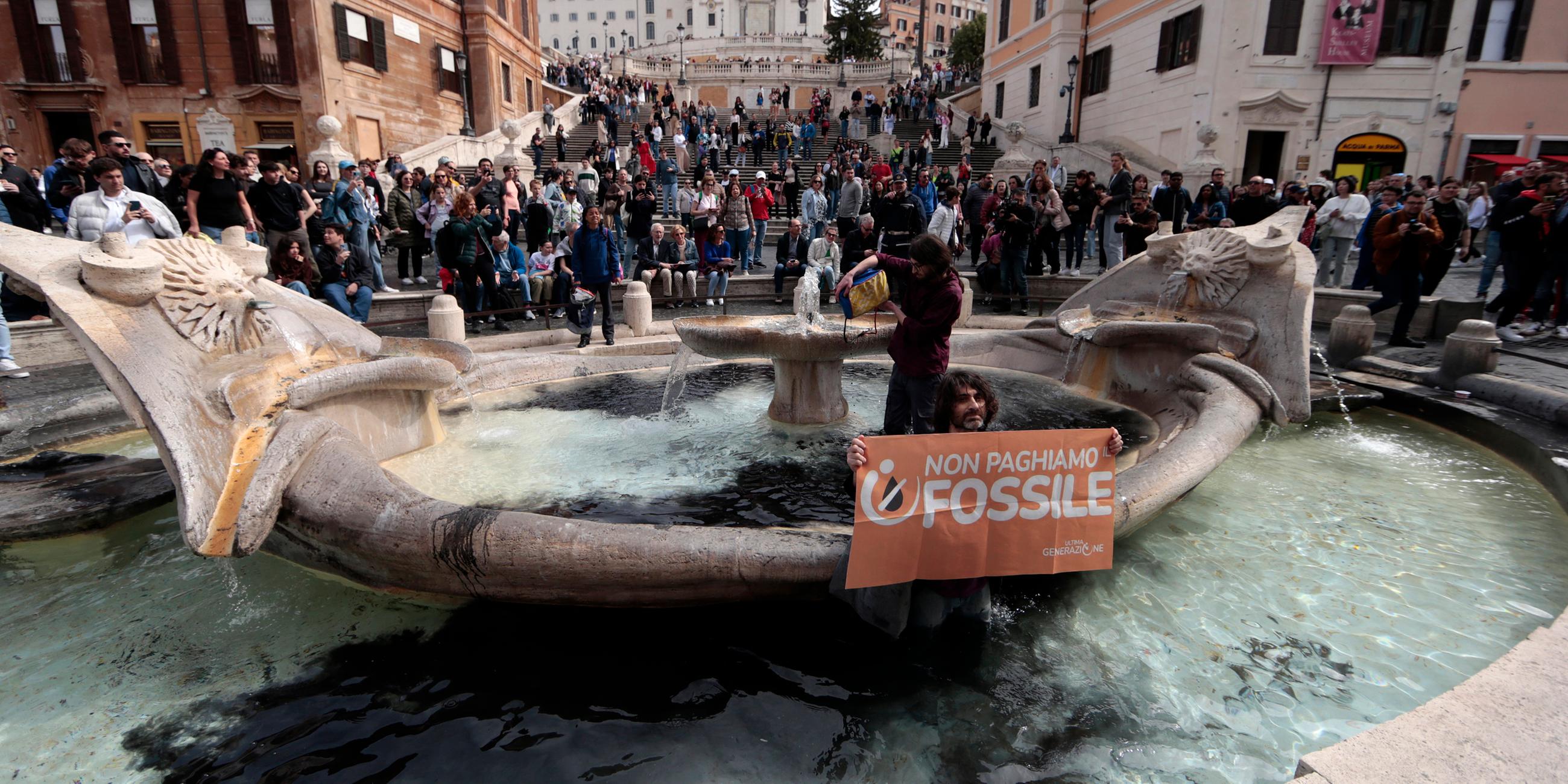 Umweltaktivisten protestieren am Samstag, 1. April 2023, vor der Spanischen Treppe auf der Piazza di Spagna in Rom an der "Fontana della Barcaccia" (Bootsbrunnen).