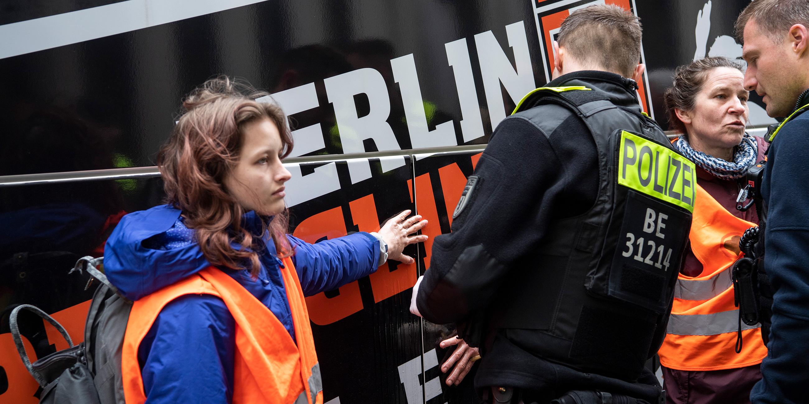 Klimaaktivisten haben sich an einem Reisebus vor dem Marriott Hotel am Potsdamer Platz geklebt