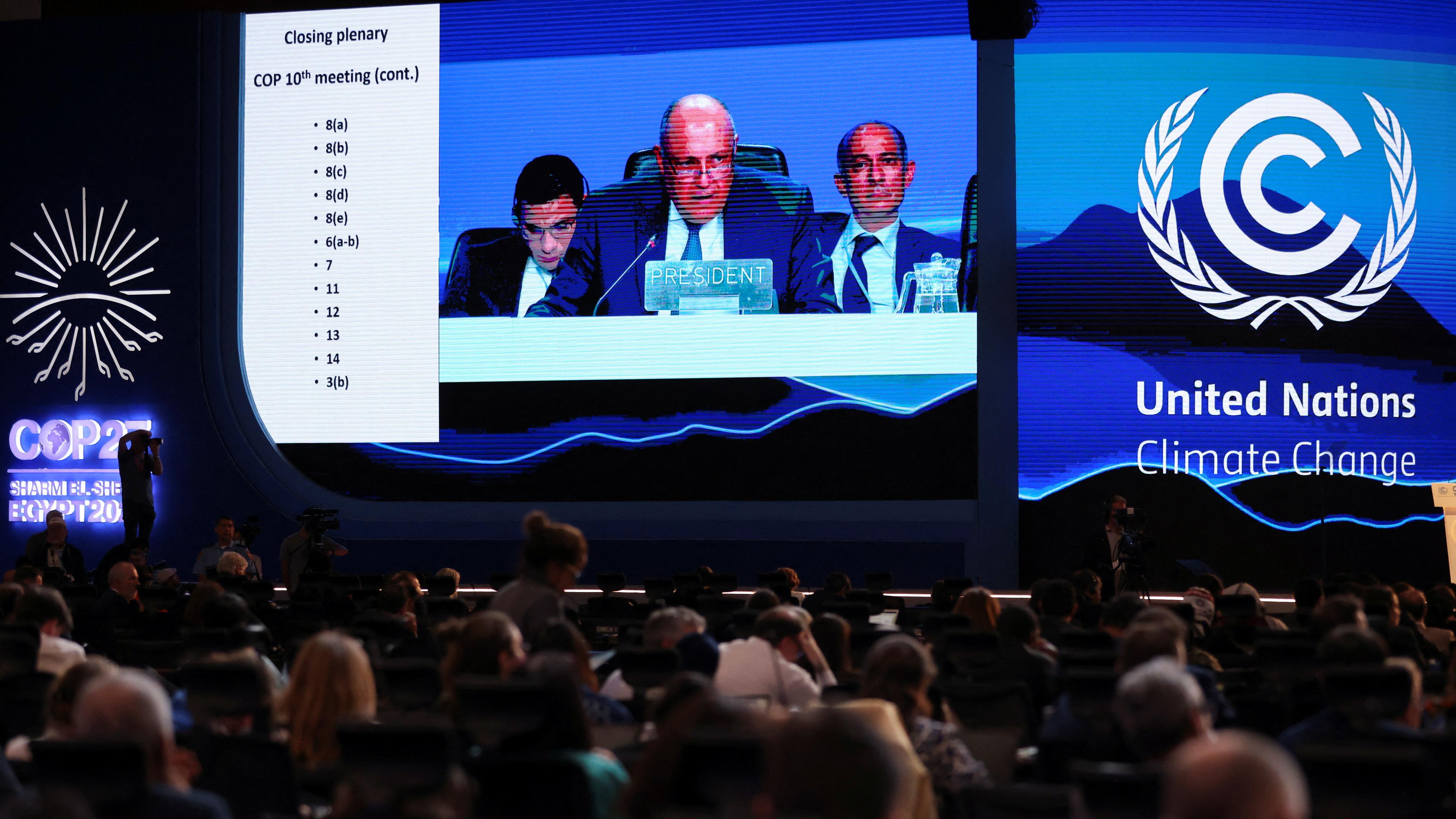 COP27 Präsident Sameh Shoukry ist auf einem großen Bildschirm Bildschirm zu sehen während seiner Rede. Im Vordergrund ist Publikum.