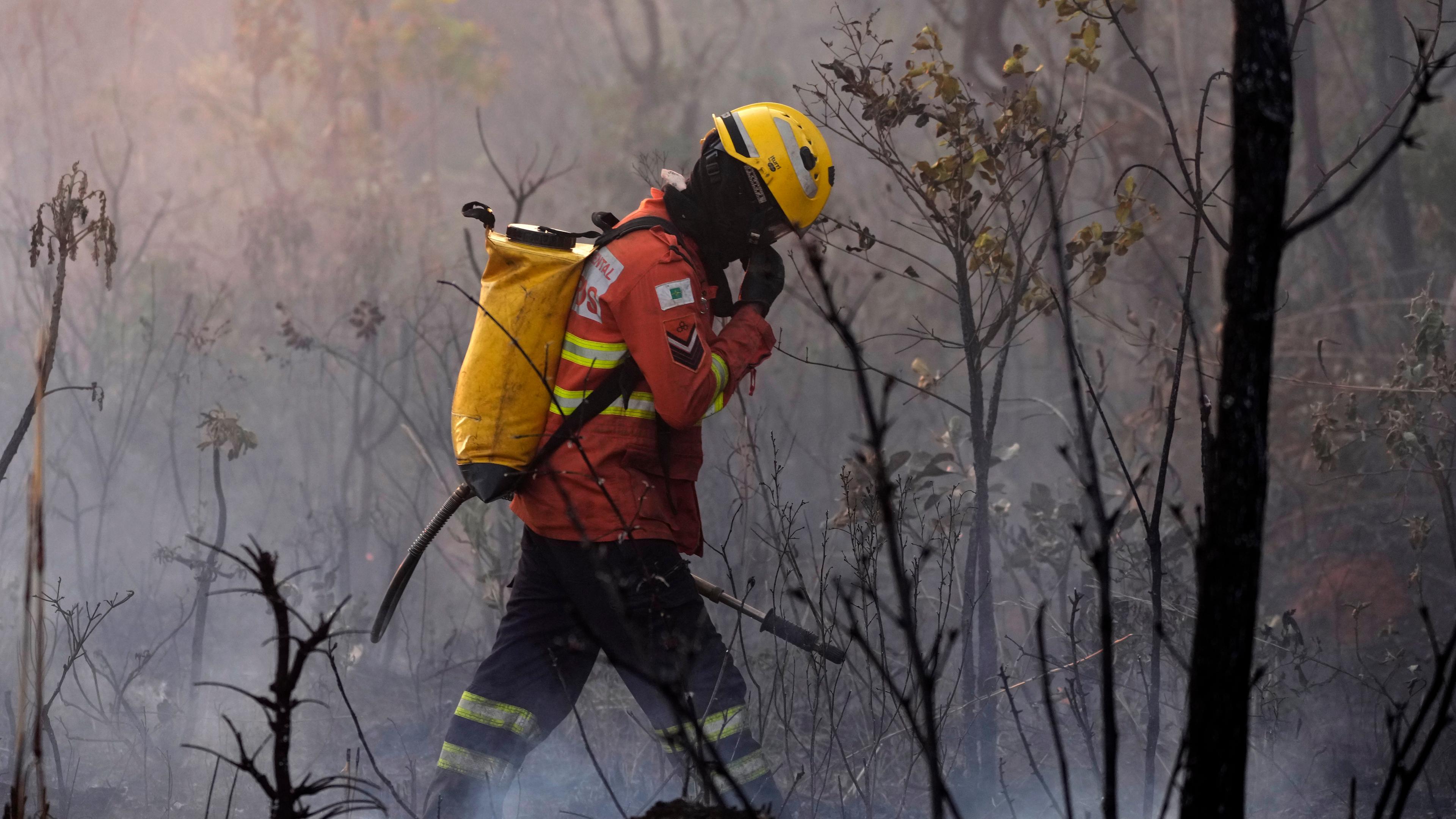 Brasilien, Ökologische Station Aguas Emendadas: Ein Feuerwehrmann geht durch ein von einem Waldbrand verkohltes Gebiet in der ökologischen Station Aguas Emendadas nordöstlich von Brasilia.