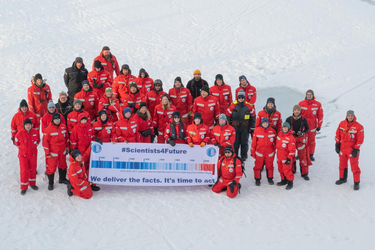 Forscher und Wissenschaftlerinnen des Alfred Wegener Instituts die mit dem Forschungsschiff "Polarstern" unterwegs sind, stehen in der Arktis mit einem Transparent, das die Aufschrift "#Scientists4Future - We deliver the facts.