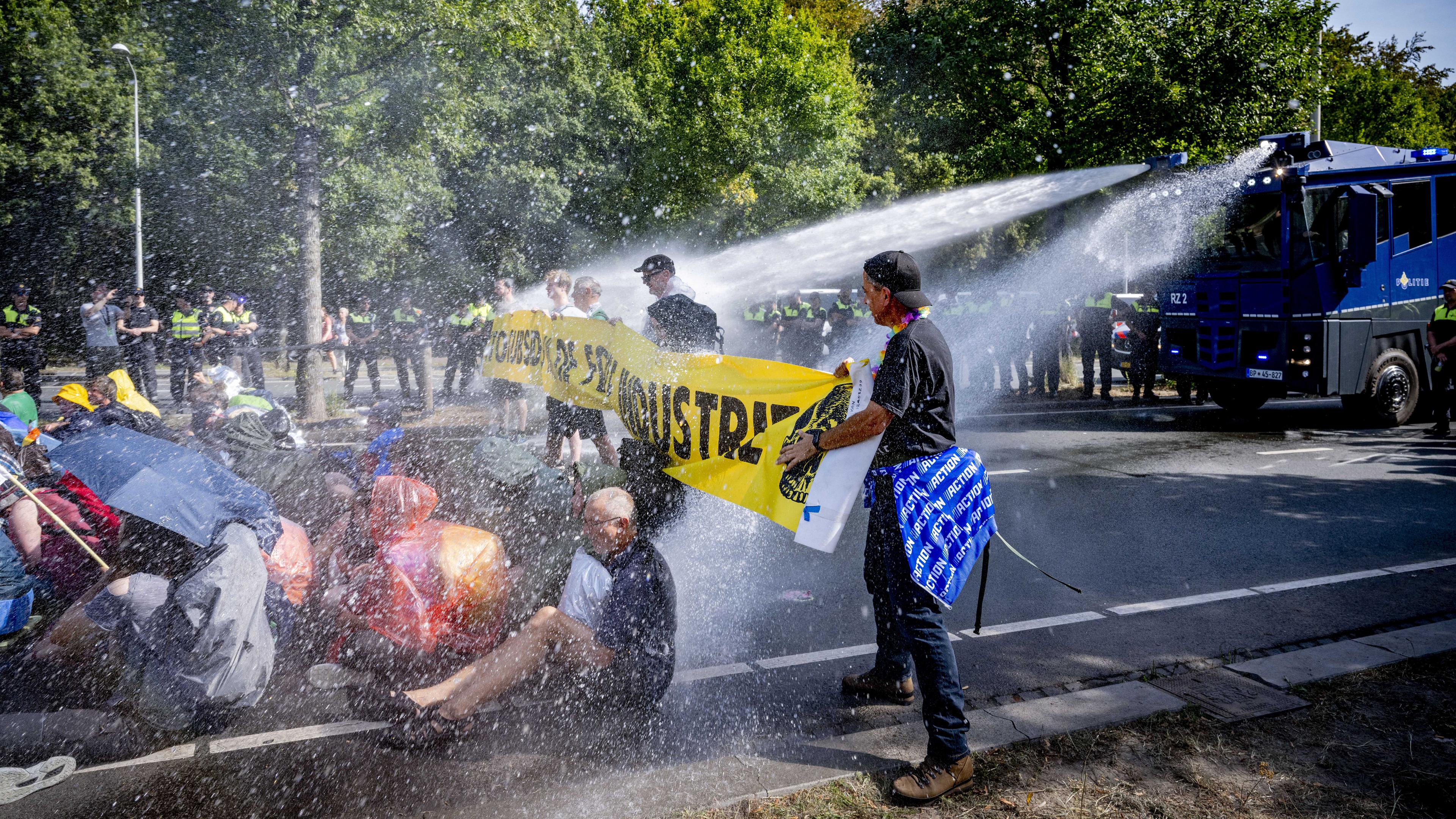 Niederlande, Den Haag: Polizisten setzten Wasserwerfer gegen Klimaaktivisten, die eine Straße blockieren, ein.