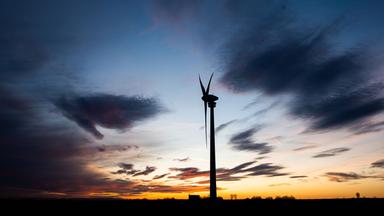 Ein Windrad dreht sich vor einem vom Sonnenuntergang verfärbten Abendhimmel, aufgenommen am 19.12.2019 in Hannover