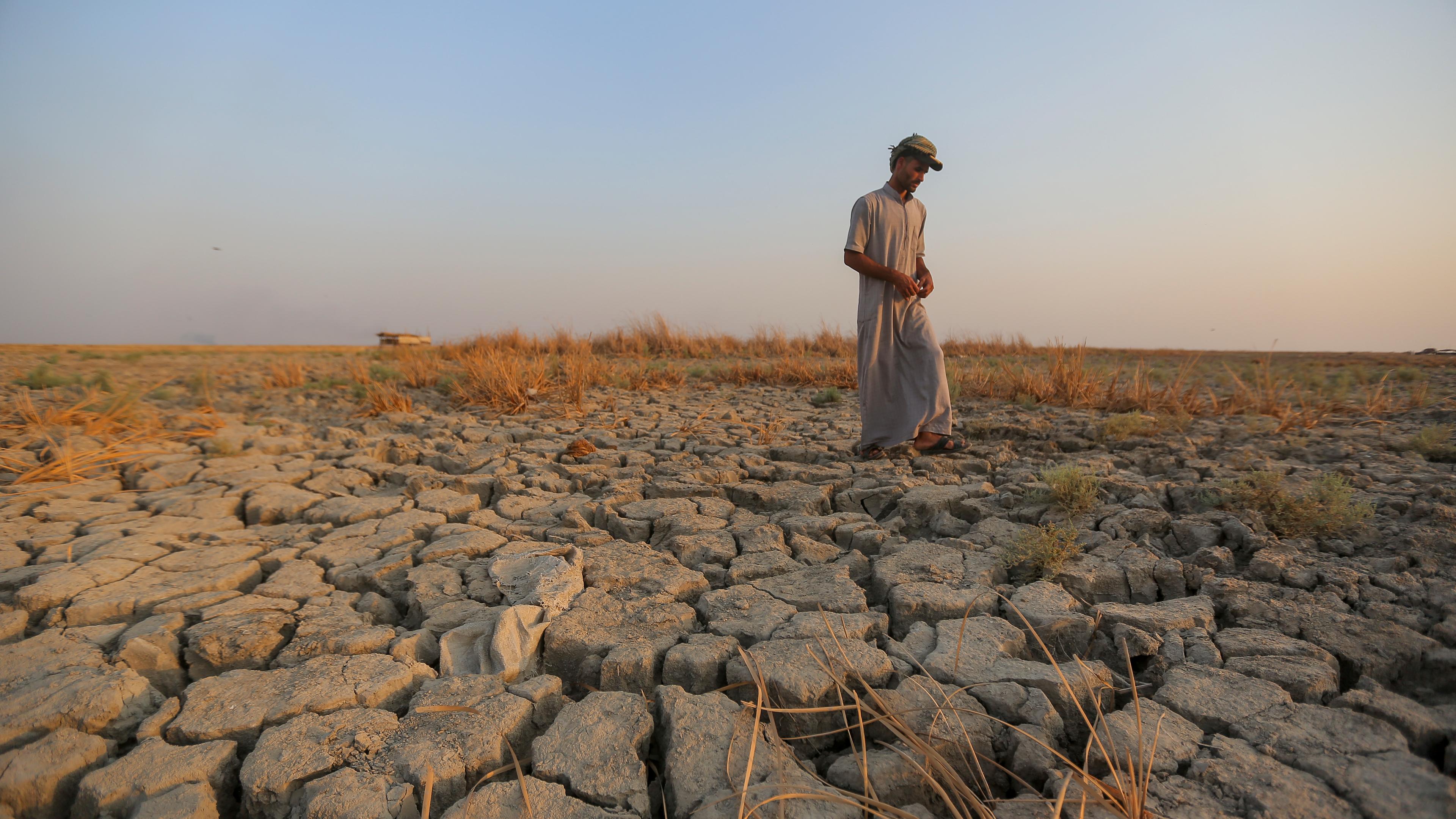 Ein Fischer geht in der irakischen Provinz Dhi Qar über ein trockenes Stück Land. 