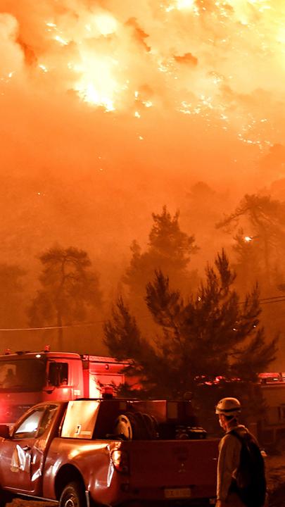 Zu sehen sind Feuerwehrmänner, die einen Waldbrand in Griechenland bekämpfen. 