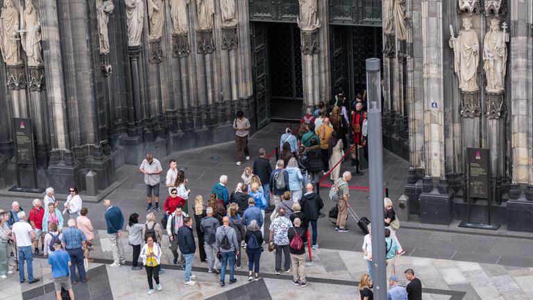 Besucher stehen vor dem Dom in Köln.