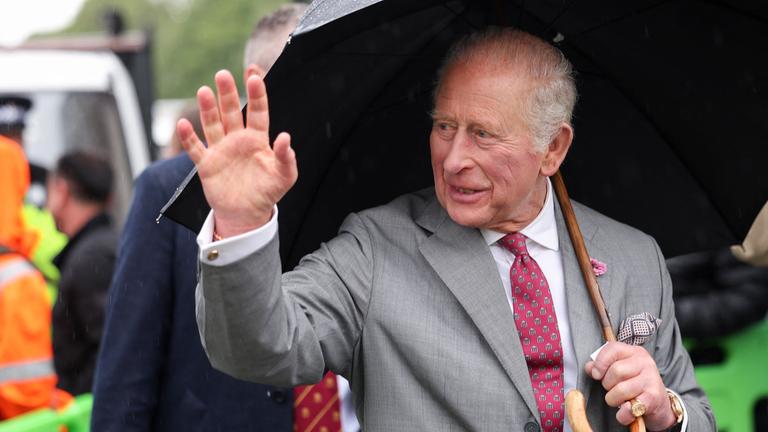 König Charles III. winkt den Bürgern während eines Besuchs im The CARE Hub zu.