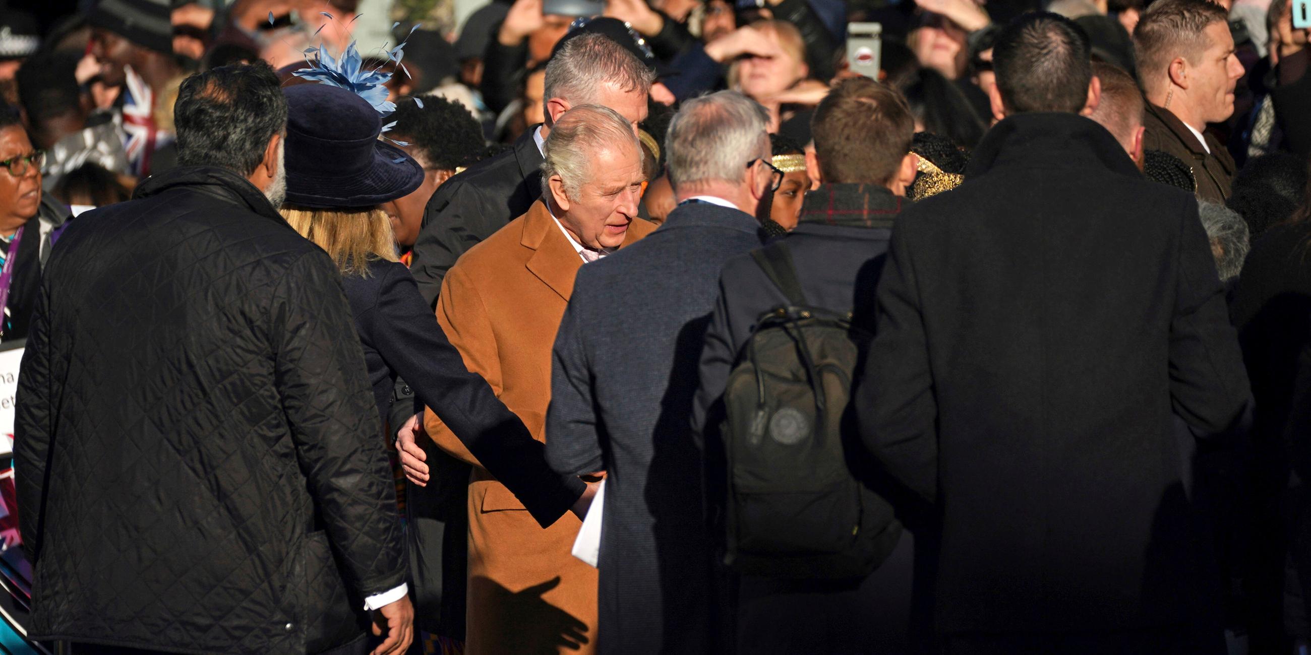 Großbritannien, Luton: Sicherheitskräfte führen König Charles III. weg von der Menschenmenge