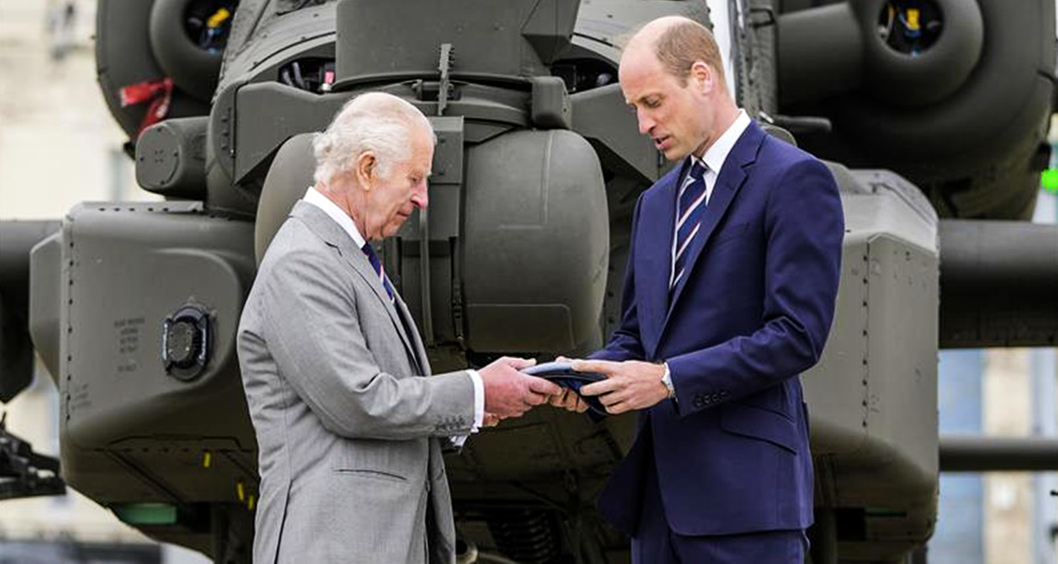 König Charles übergibt etwas an Prinz William 