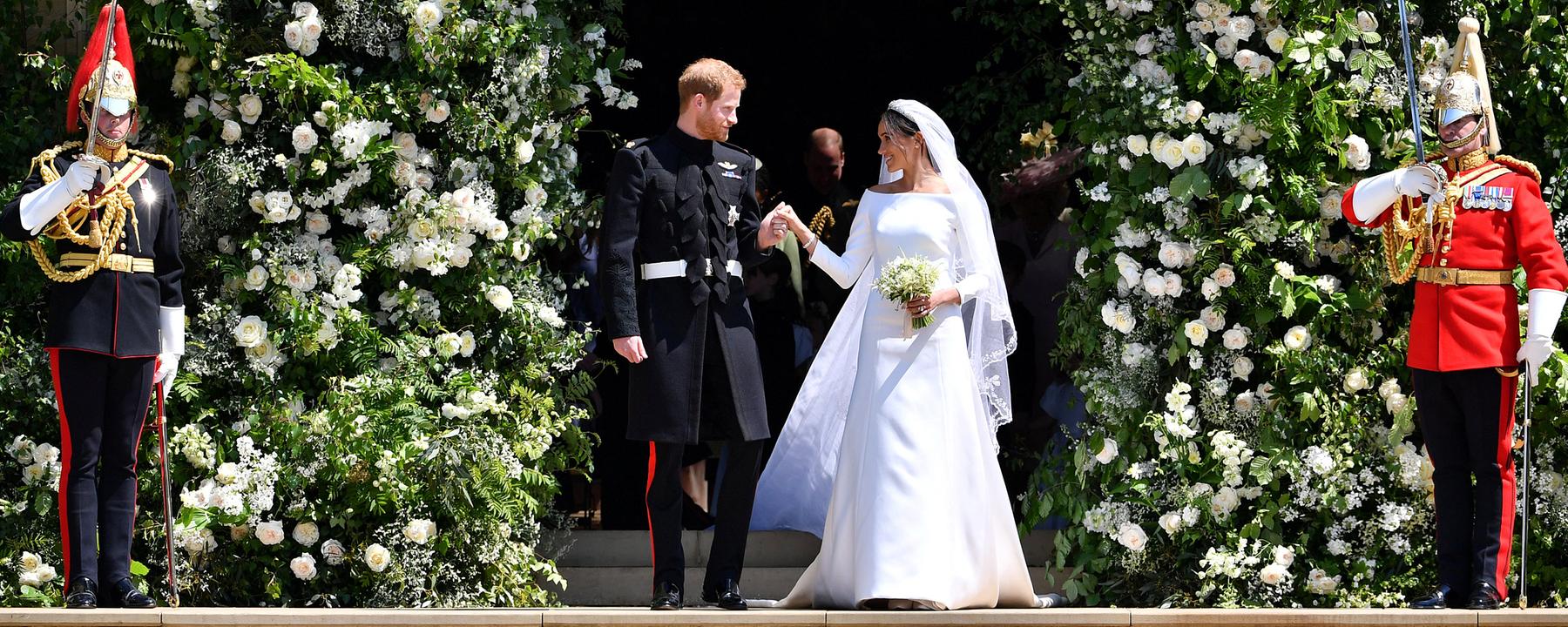 Prinz Harry von Großbrittanien und seine Frau Herzogin Meghan bei der Hochzeit, am 19.Mai 2018. Rechts und links von ihnen stehen Wachen.