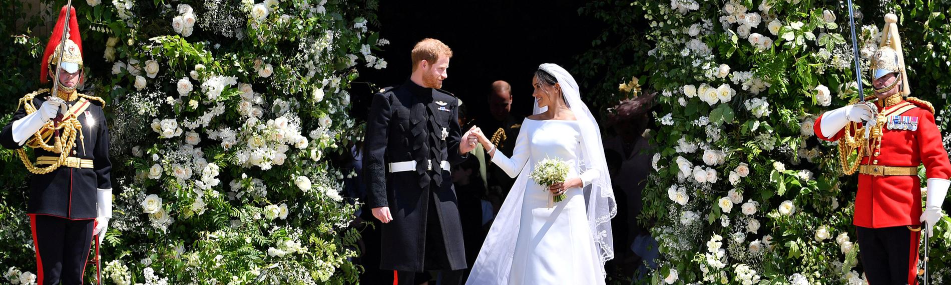 Prinz Harry von Großbrittanien und seine Frau Herzogin Meghan bei der Hochzeit, am 19.Mai 2018. Rechts und links von ihnen stehen Wachen.