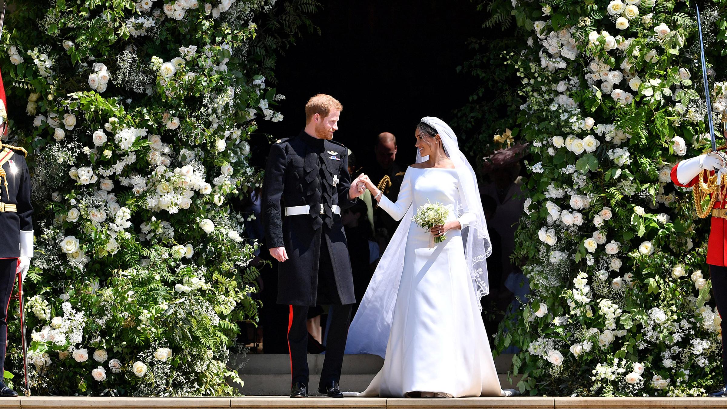 Prinz Harry von Großbrittanien und seine Frau Herzogin Meghan bei der Hochzeit, am 19.Mai 2018. Rechts und links von ihnen stehen Wachen.