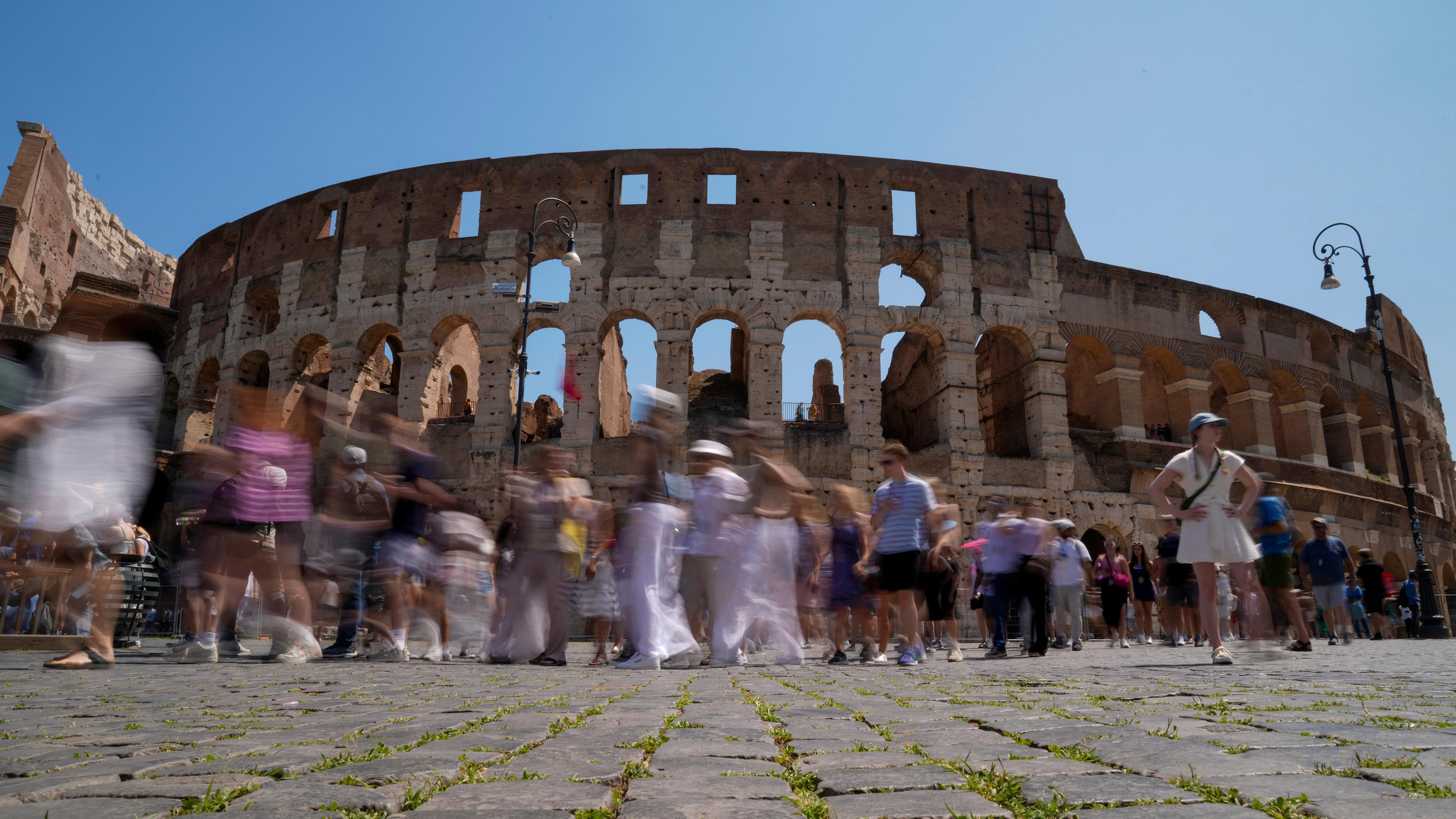 Besucher gehen am Kolosseum in Rom vorbei.