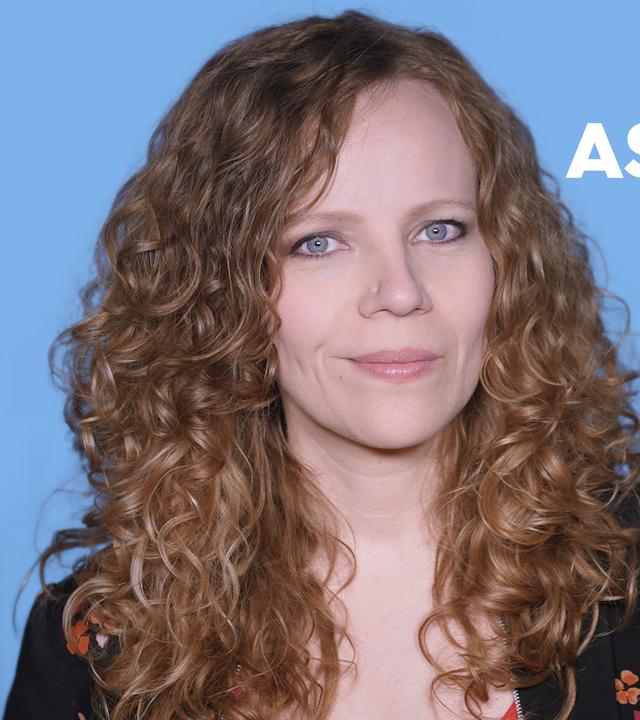 Sarah Bosetti befindet sich vor einem blauen Hintergrund. Rechts neben ihr steht "60 Prozent weniger Asylbewerber?". In einer Sprechblase darunter steht "Kommentarspalte".