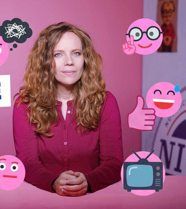 Sarah Bosetti sitzt an einem Tisch vor einem rosa Hintergrund. Um sie herum sind verschiedene Symbole und Emojis zu sehen. Links steht groß das Wort "KOMMENTARE".