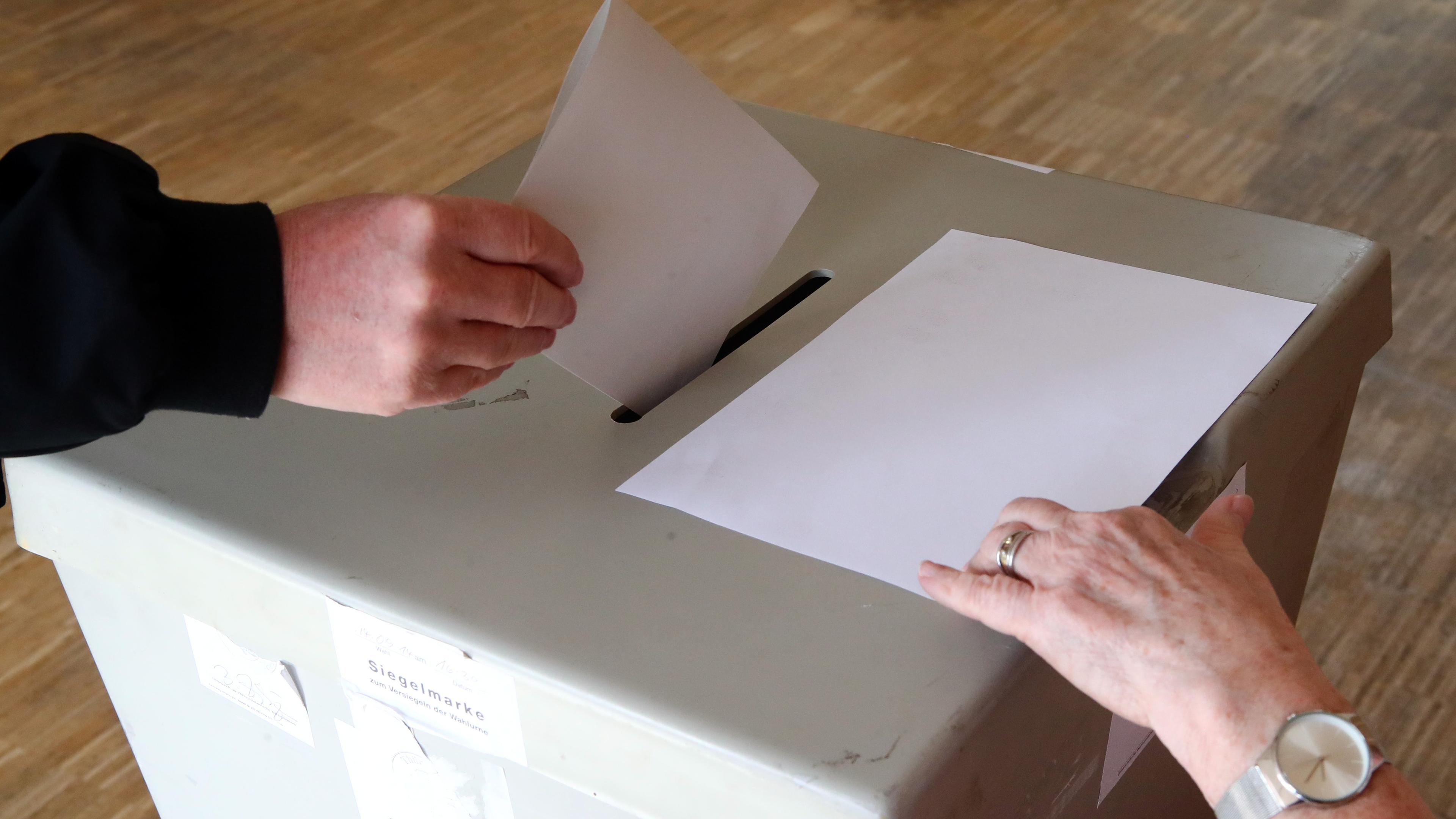 Eine Wählerin wirft ihren Wahlschein in einem Wahllokal in die Wahlurne. 