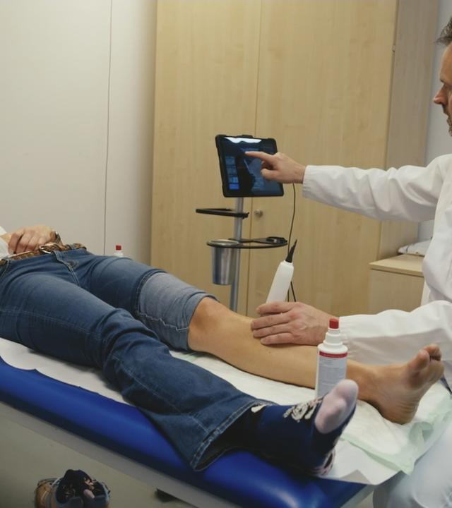 Eine Frau liegt auf einer Liege beim Arzt