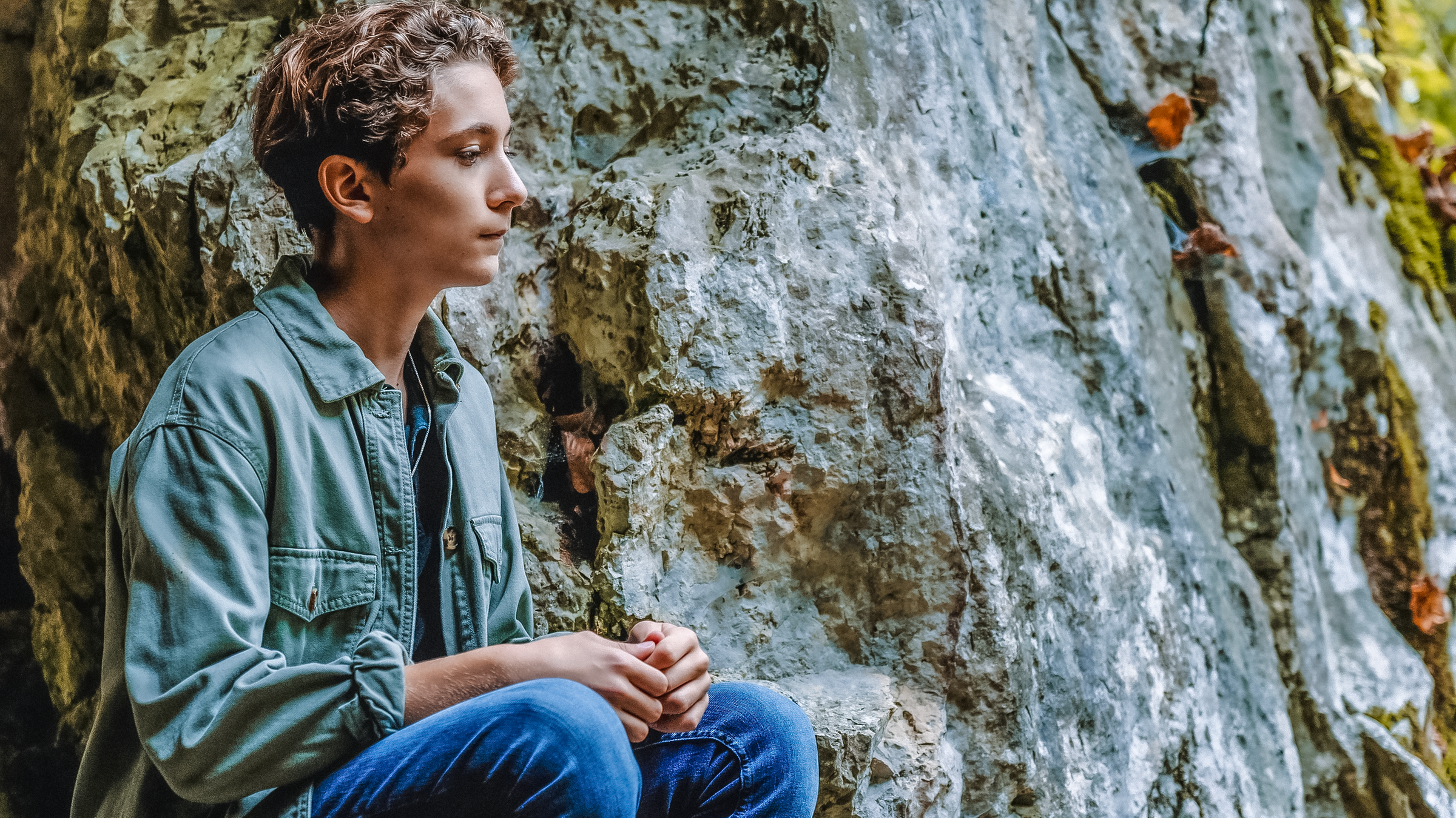 Benny sitzt nachdenklich und allein am Eingang der Höhle.