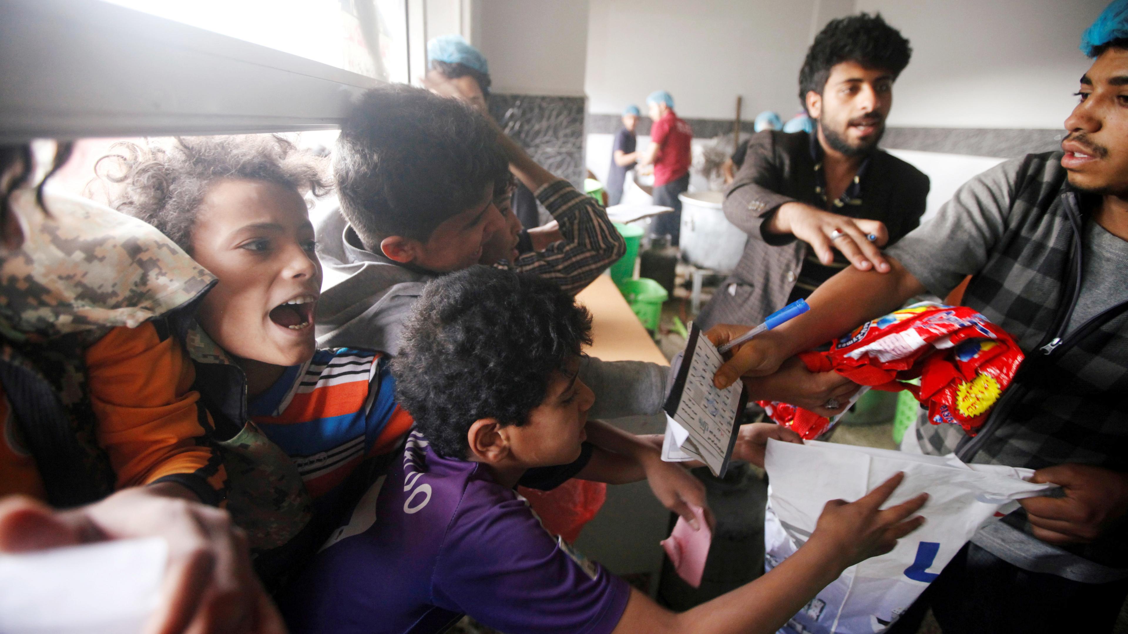 Jungen reagieren, während sie darauf warten, ihr Essen in einer Wohltätigkeitsküche zu bekommen in Sanaa (Jemen) zu, aufgenommen am 16.05.2019