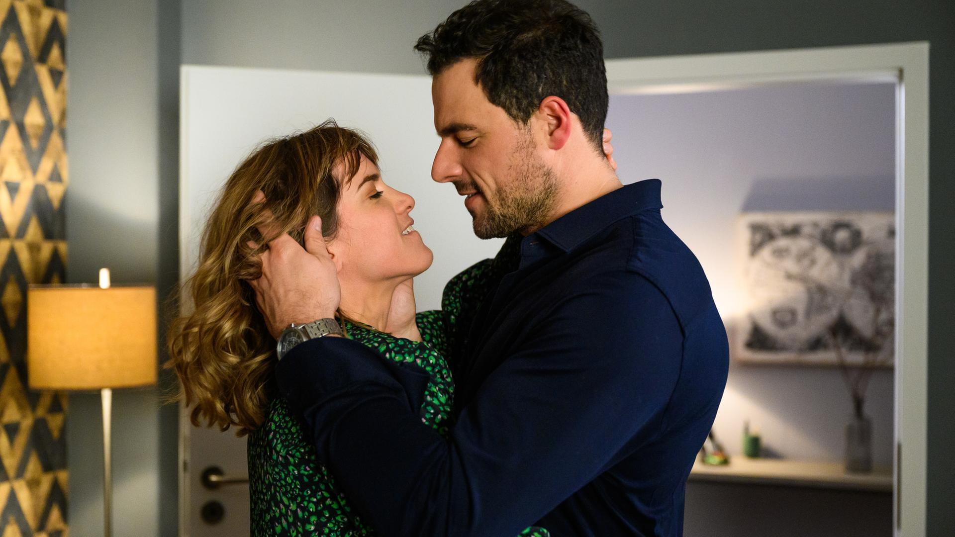 "Bettys Diagnose - Konfrontation": Dr. Koopmann (Tobias Licht) und Rike (Isabell Horn) stehen in seinem Wohnzimmer und halten sich in den Armen. Sie sind kurz davor, sich zu küssen.