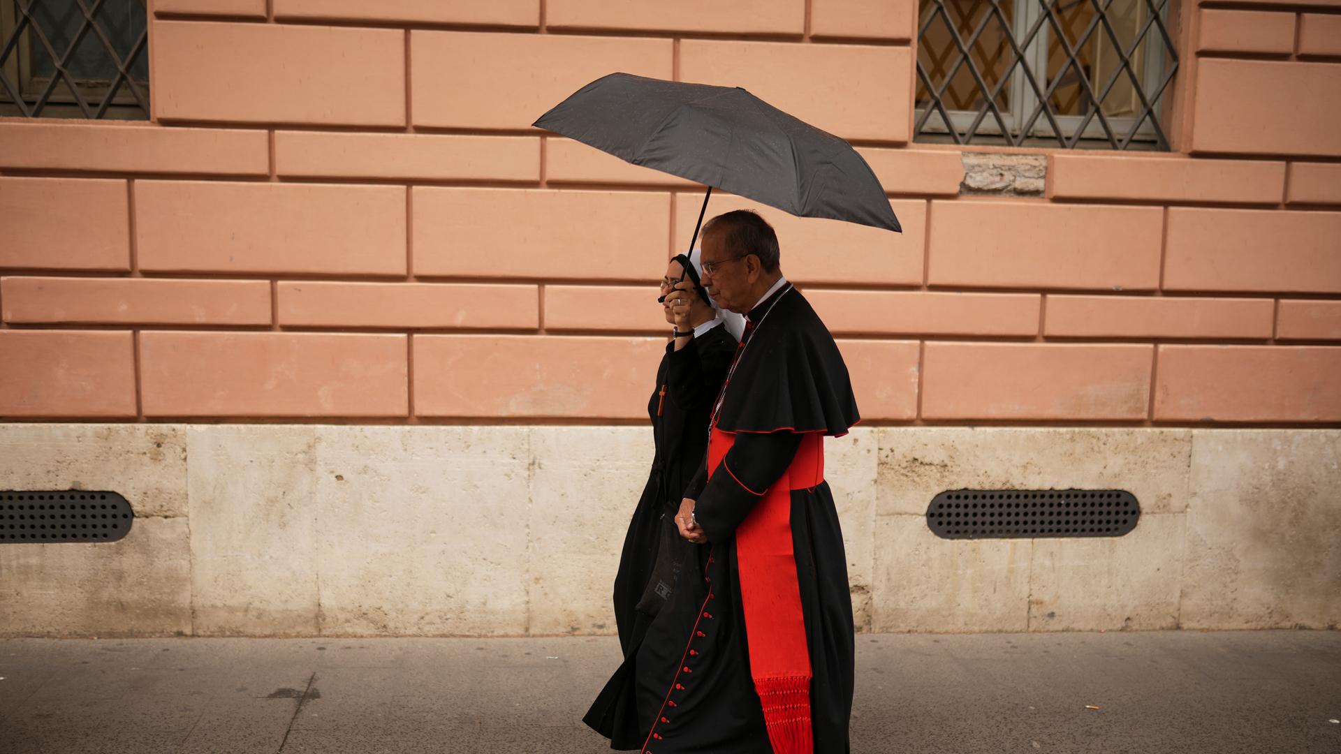 Kardinal Gregorio Rosa Chavez geht vor dem Konklave zur Wahl eines neuen Papstes mit Regenschirm in der Hand auf dem Petersplatz. 