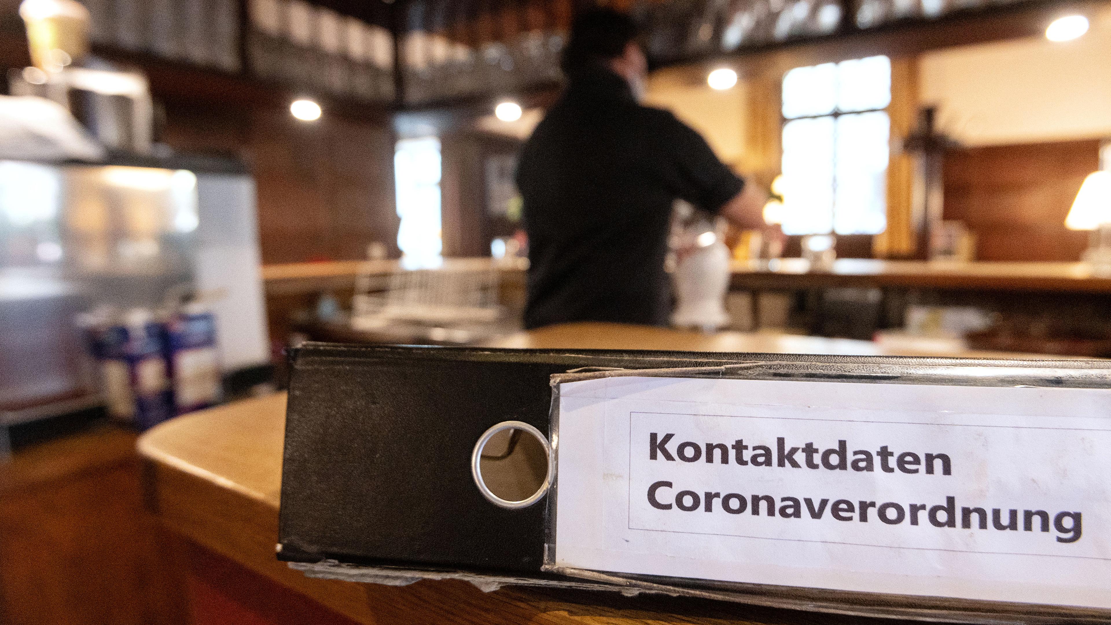 Ein Ordner mit der Aufschrift "Kontaktdaten Coronaverordnung" liegt in einer Gaststätte auf der Theke, aufgenommen am 06.10.2020