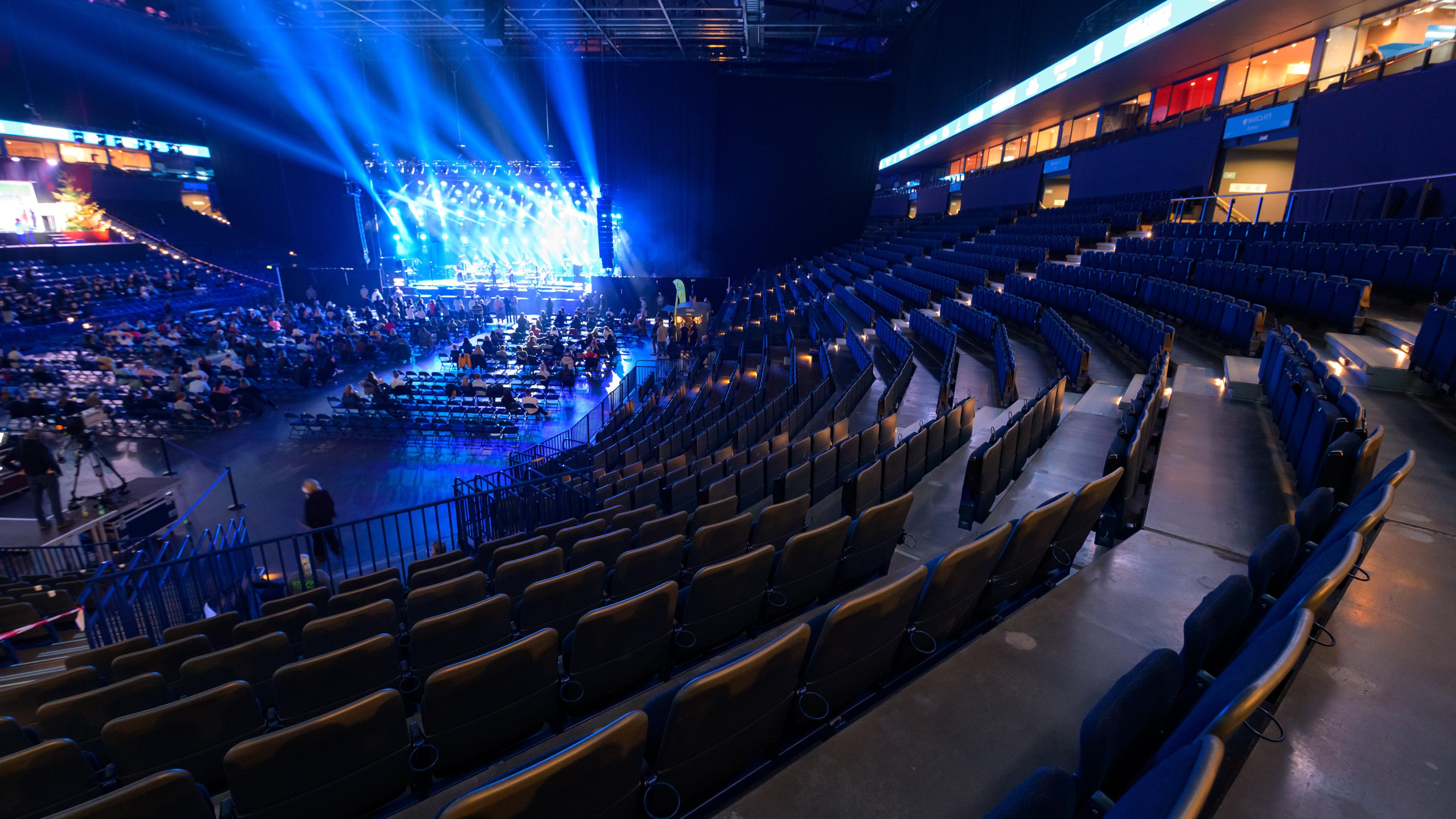 Hamburg: Zahlreiche Sitzplätze auf den Rängen der Arena sind leer, während das Publikum großteils in der Mitte vor der Bühne sitzt. 