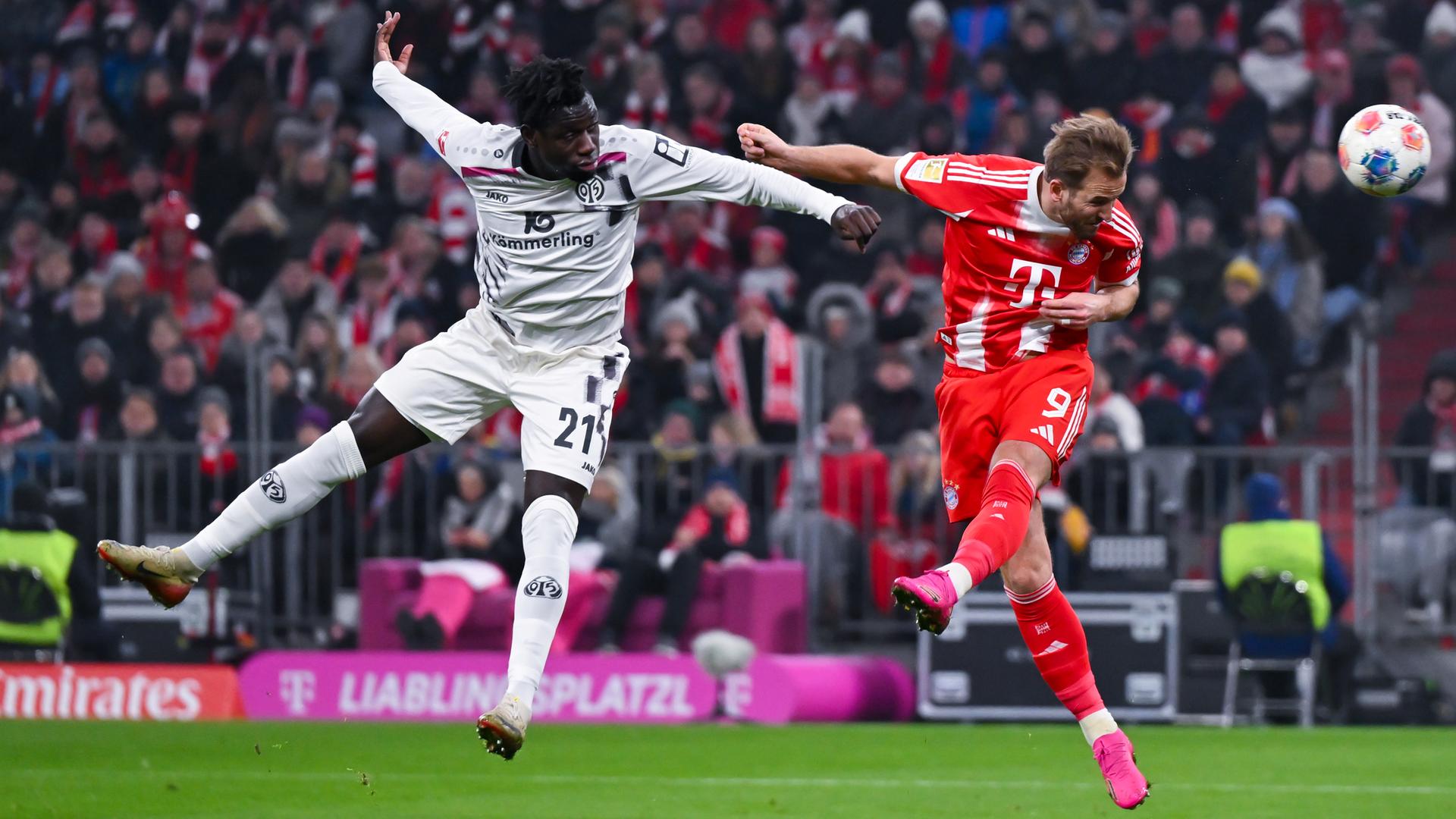 Im Kopfballduell zwischen dem Mainzer Verteidiger Danny Da Costa und Bayerns Harry Kane kann sich der Kane durchsetzen und den Ball Richtung Tor köpfen