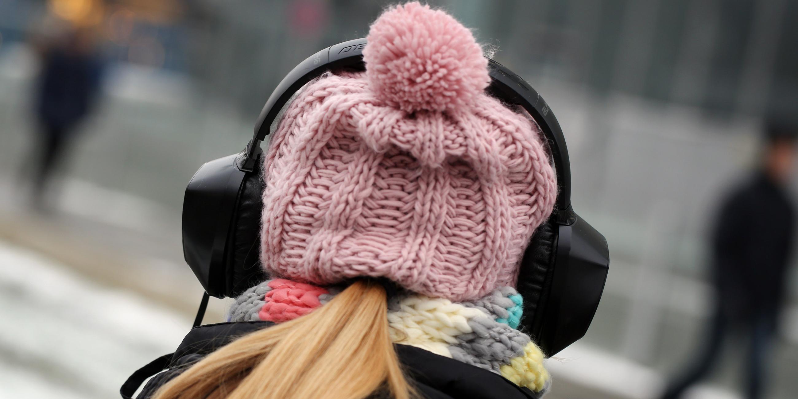 Symbolbild: Junge Frau mit Mütze und Kopfhörern
