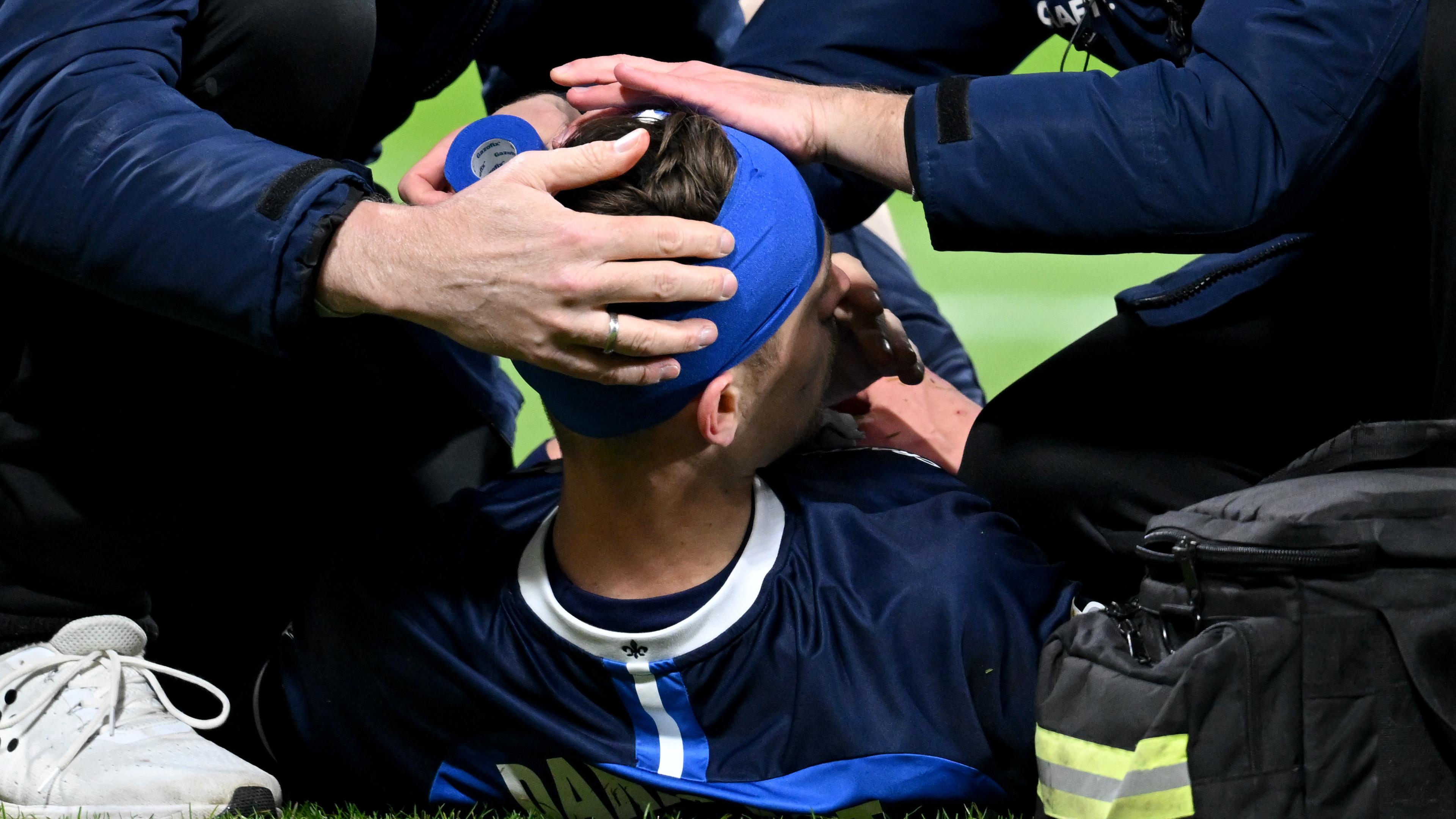 Jannik Müller von Darmstadt 98 wird mit einer Kopfverletzung behandelt