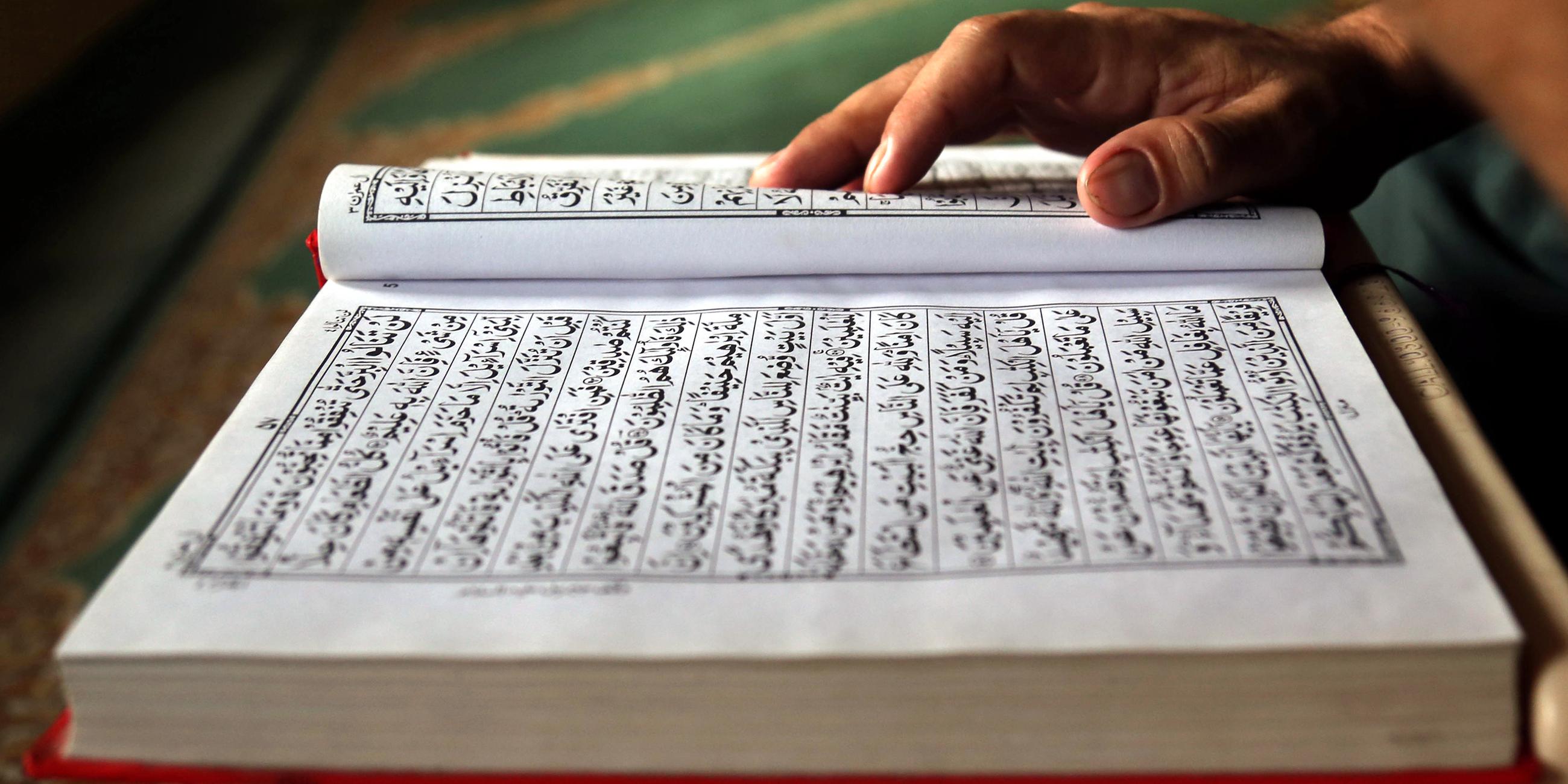 Hand liegt auf Koran