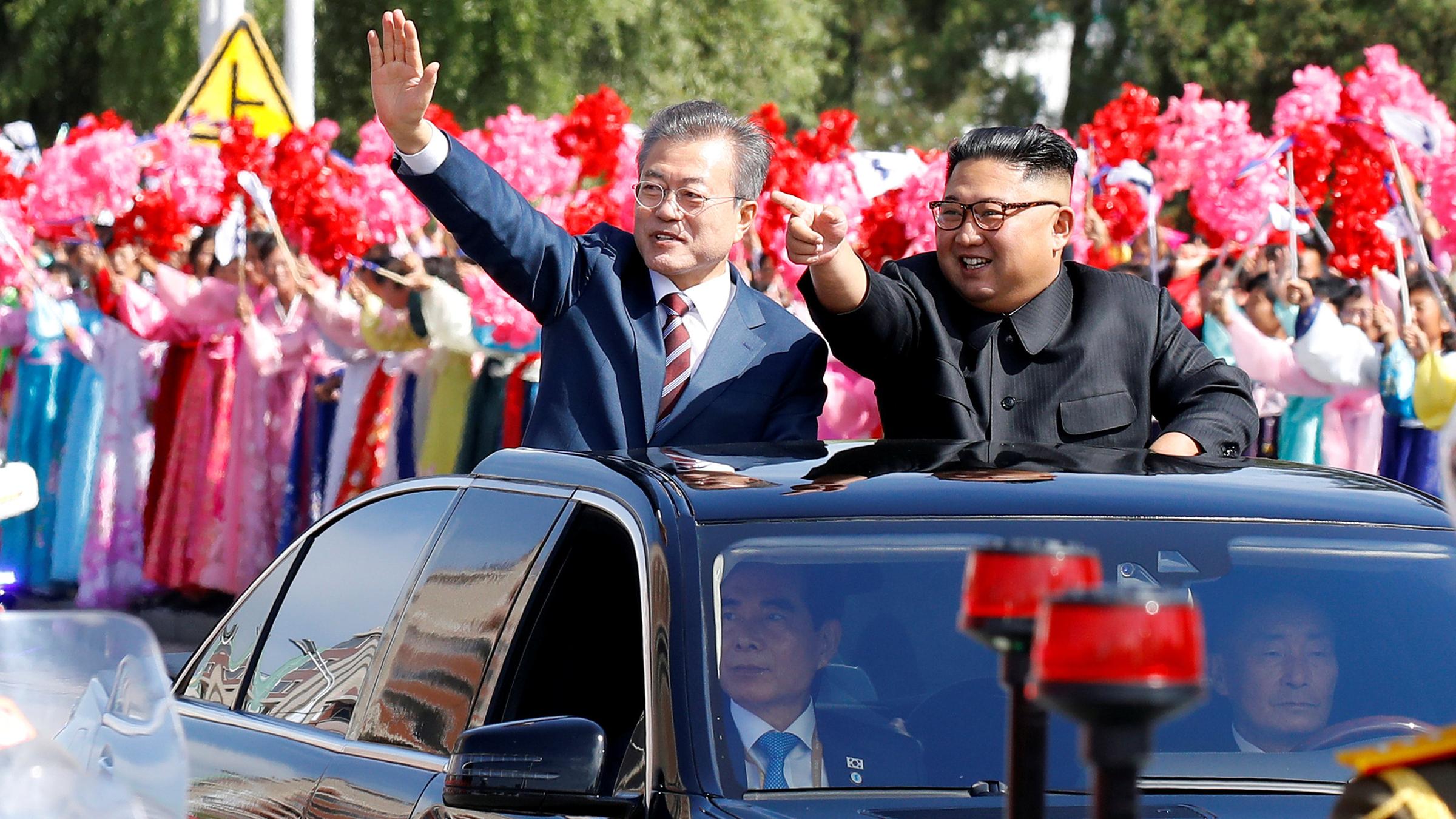 south korean president moon jae-in and north korean leader kim jong un wave during a car parade in pyongyang, north korea, september 18, 2018
