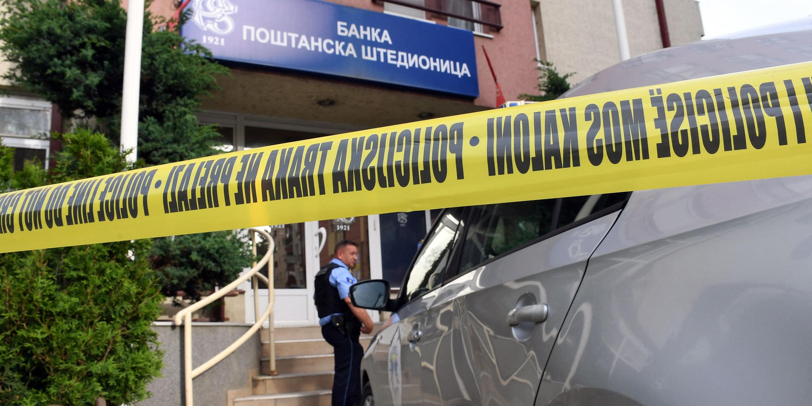 Ein kosovarischer Polizist bewacht ein Büro der serbischen "Postsparkasse".