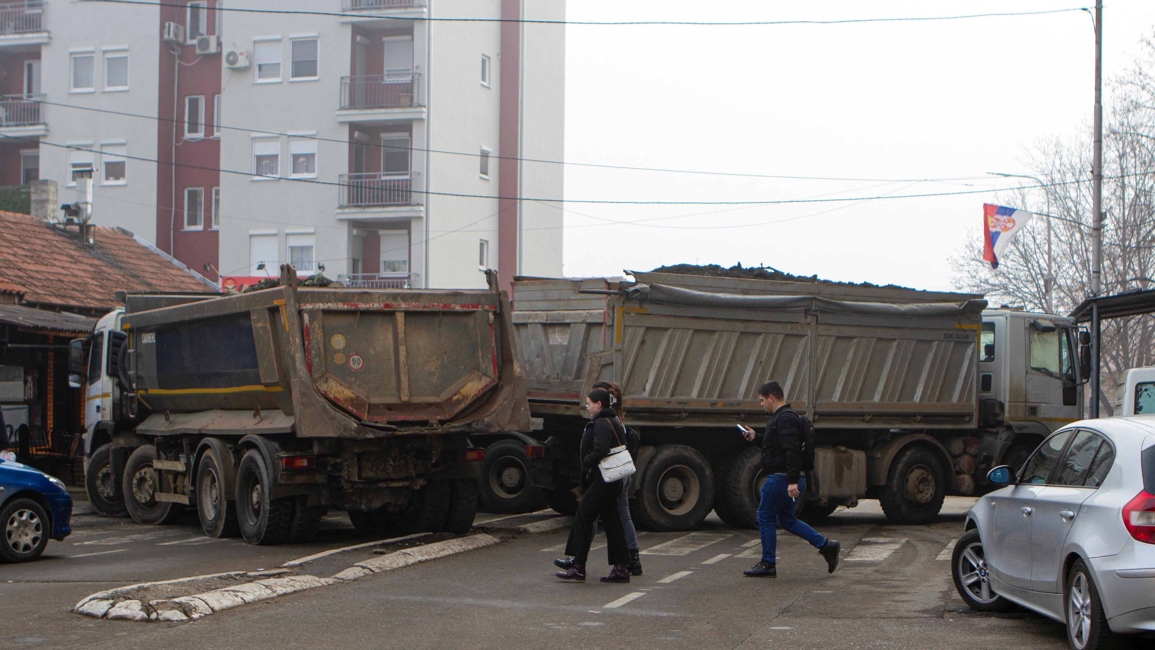 Kosovo, Mitrovica: Mehrere LKWs blockieren eine Straße.