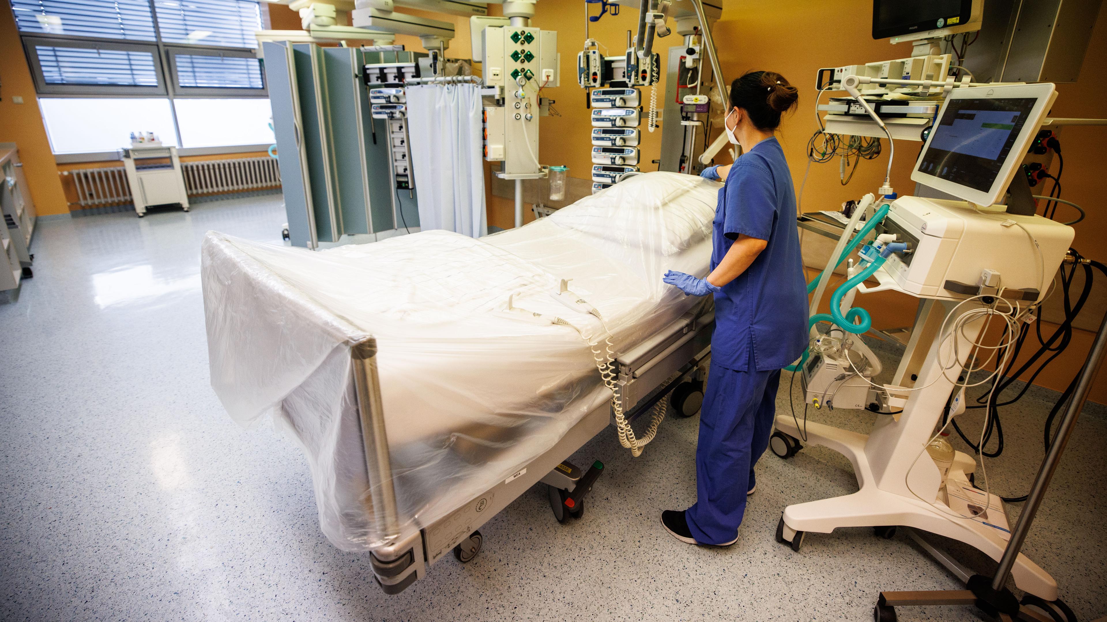 Eine Krankenschwester bereitet ein Bett in einem Intensivbett-Zimmer vor.
